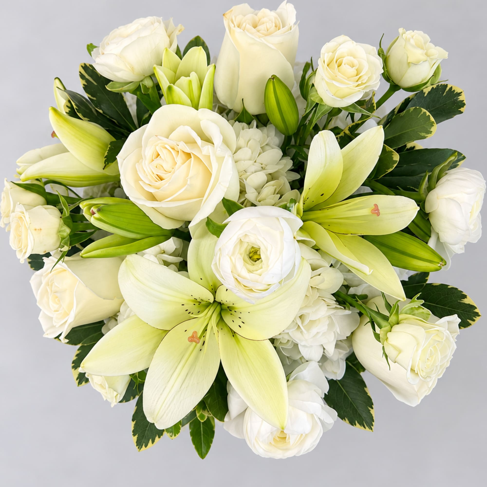 White roses and lilies arranged in a round bouquet