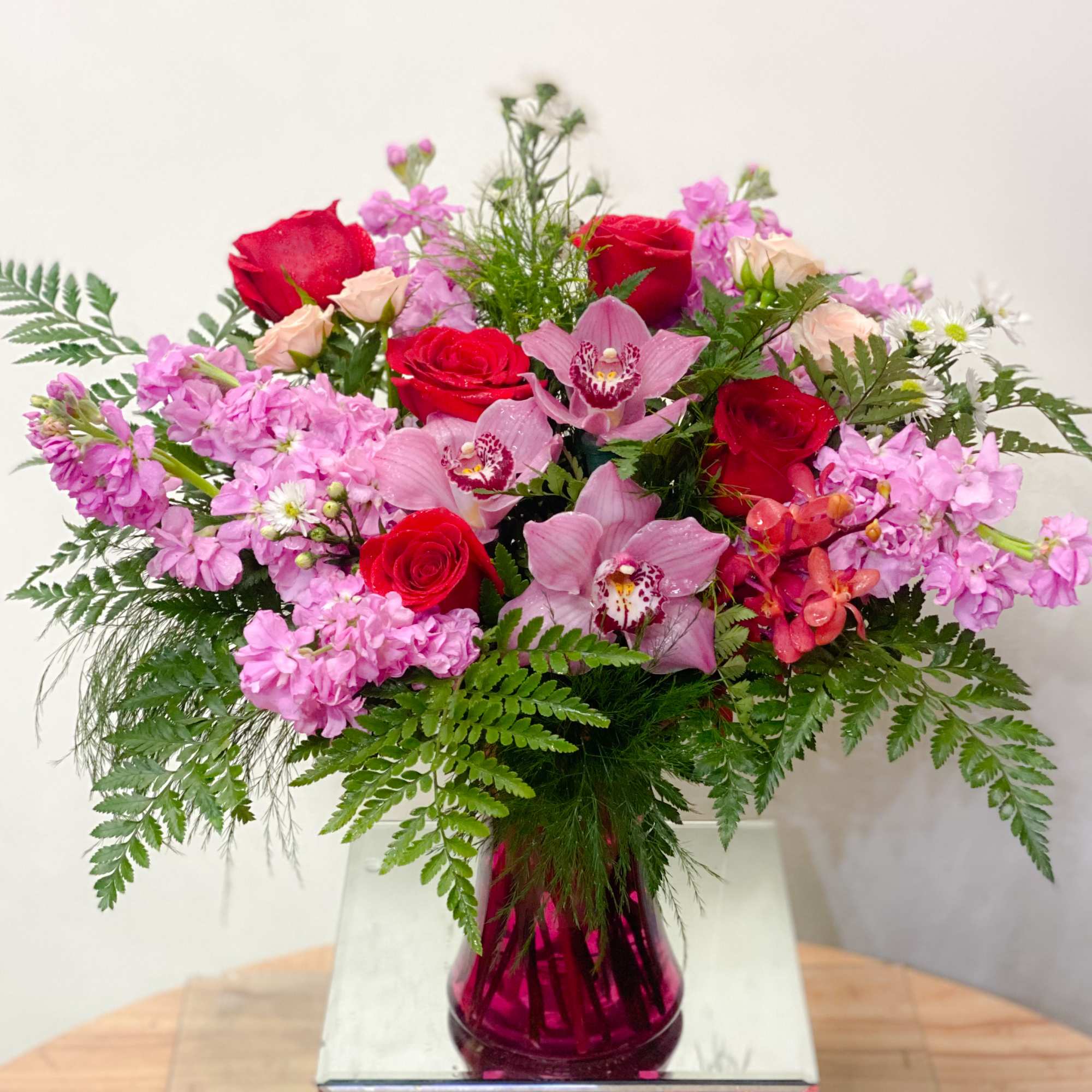 Pink and red mixed bouquet in a magenta glass vase