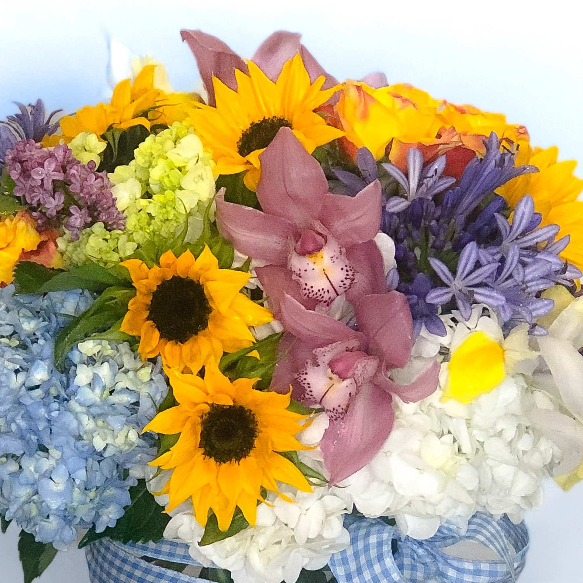 Mixed bouquet with sunflowers, orchids, hydrangeas, and lilac blooms