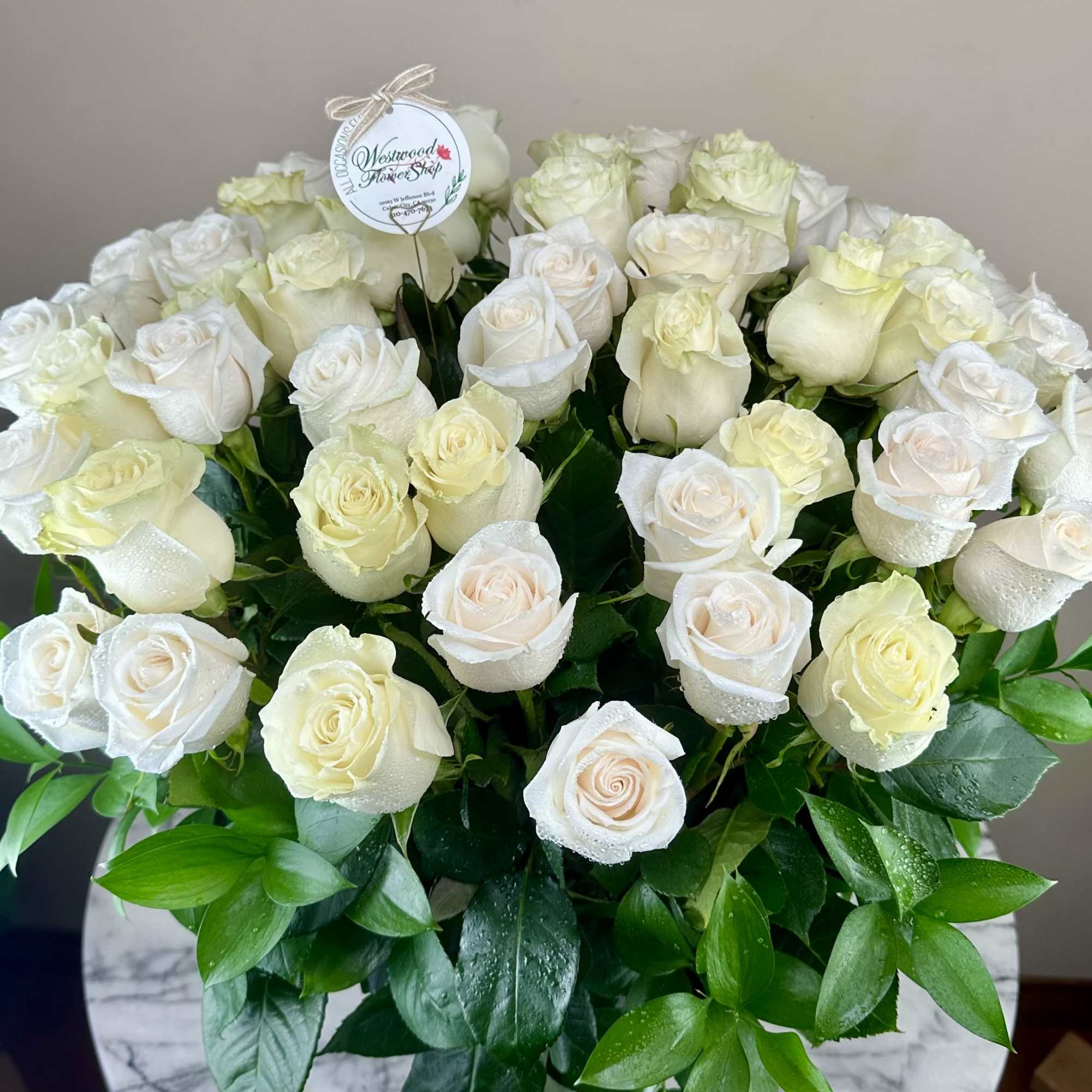 Bouquet of white roses with glossy green leaves
