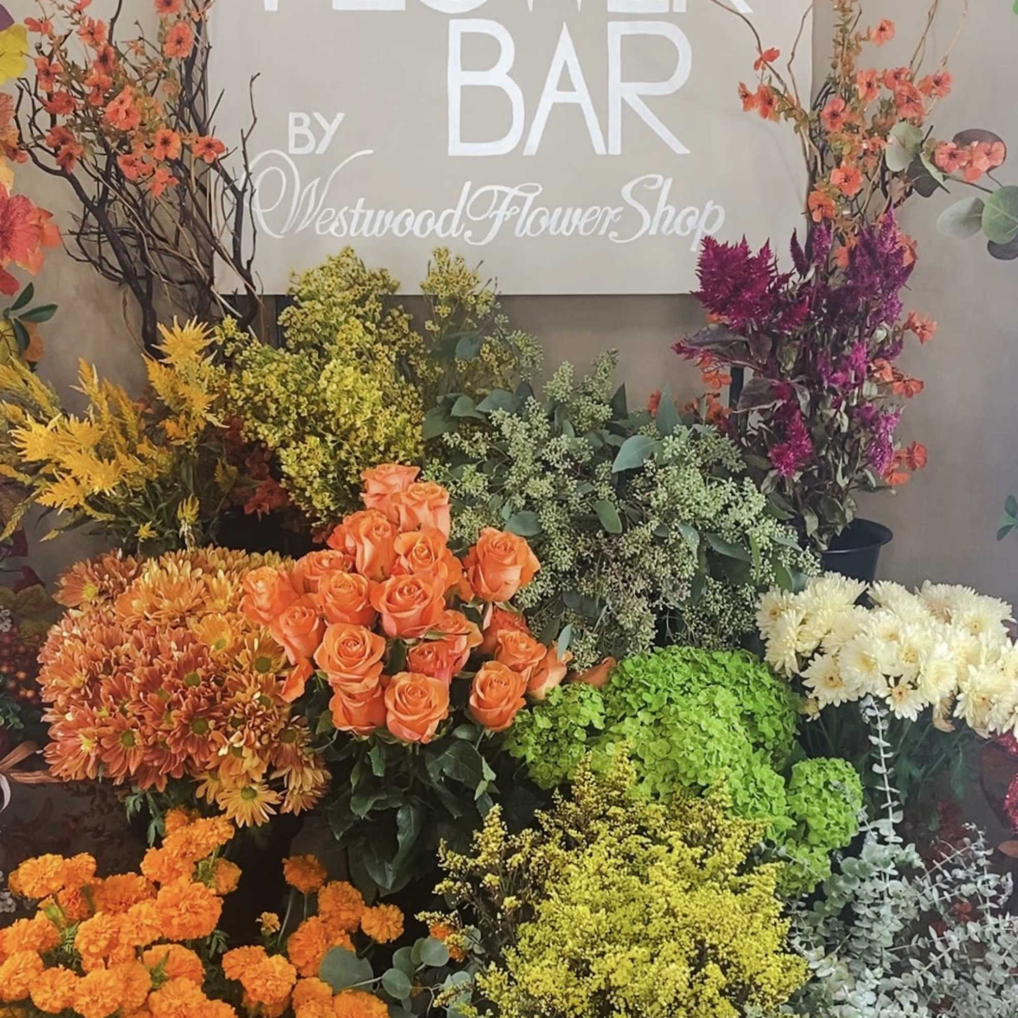 Assorted flower display with roses, chrysanthemums, and tall branches