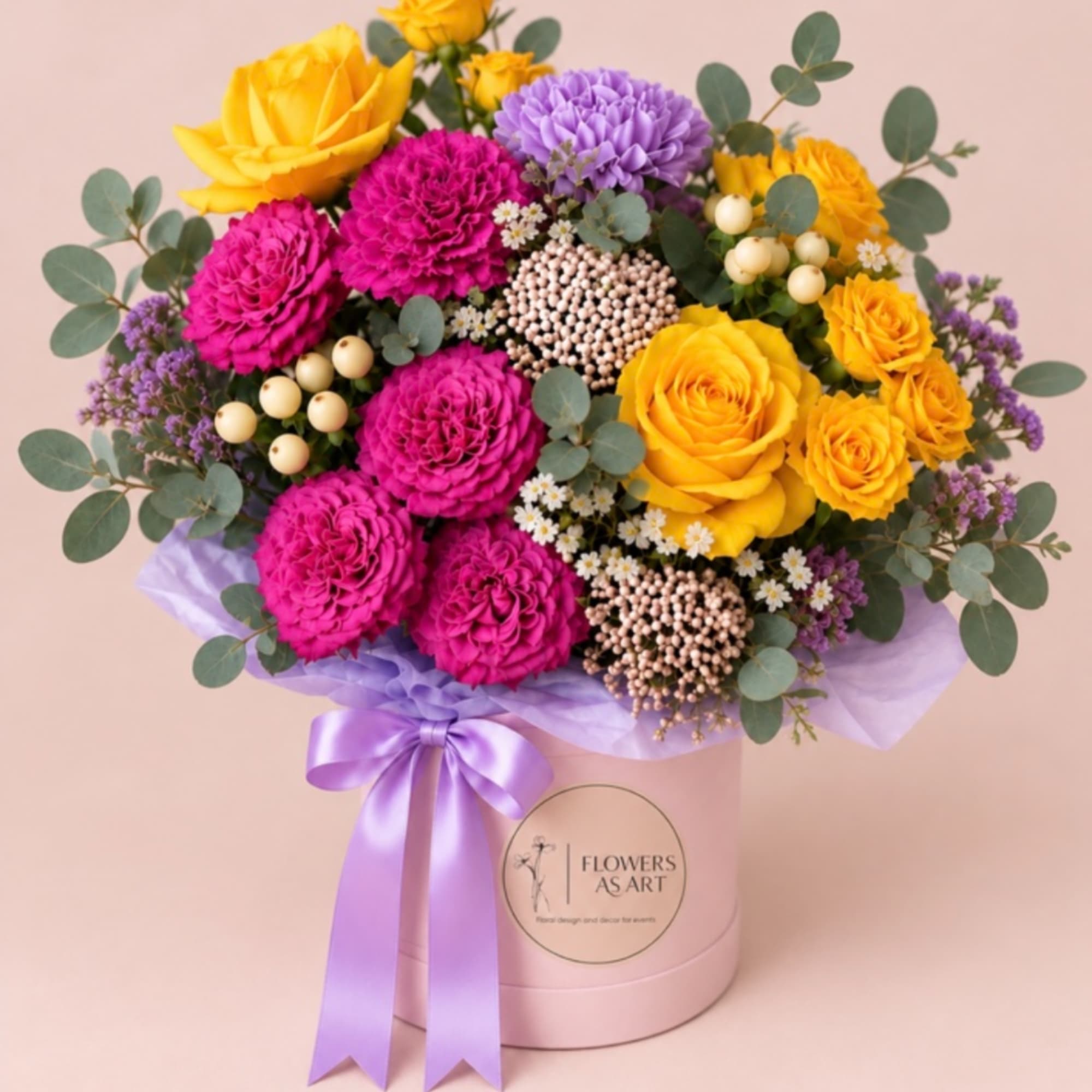 Bouquet of yellow and magenta flowers in a pink hat box with a purple ribbon