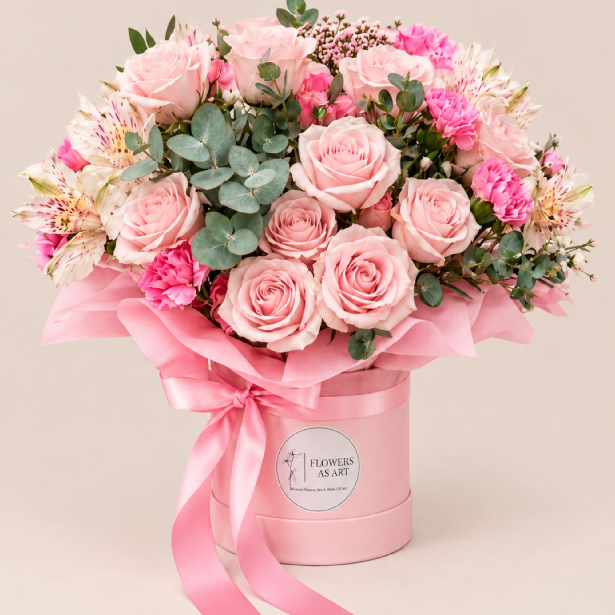 Pink roses and alstroemeria in a pink hatbox with ribbon