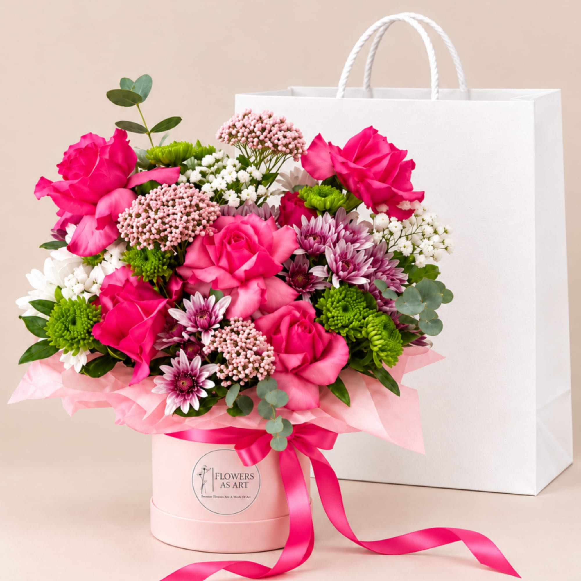 Pink and white mixed bouquet in a pink hatbox with ribbon, beside a white gift bag