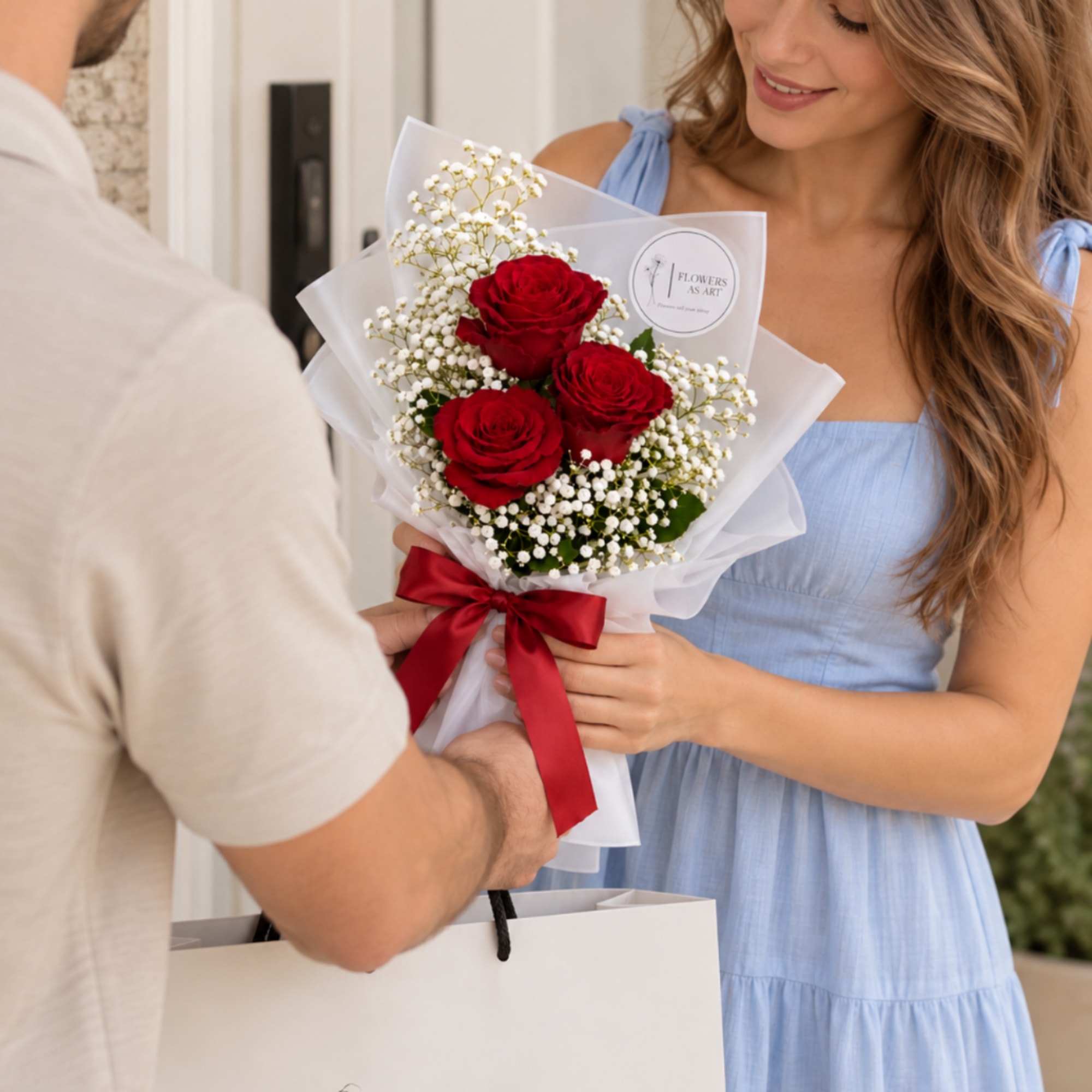 Man hands woman a bouquet of red roses wrapped in white paper