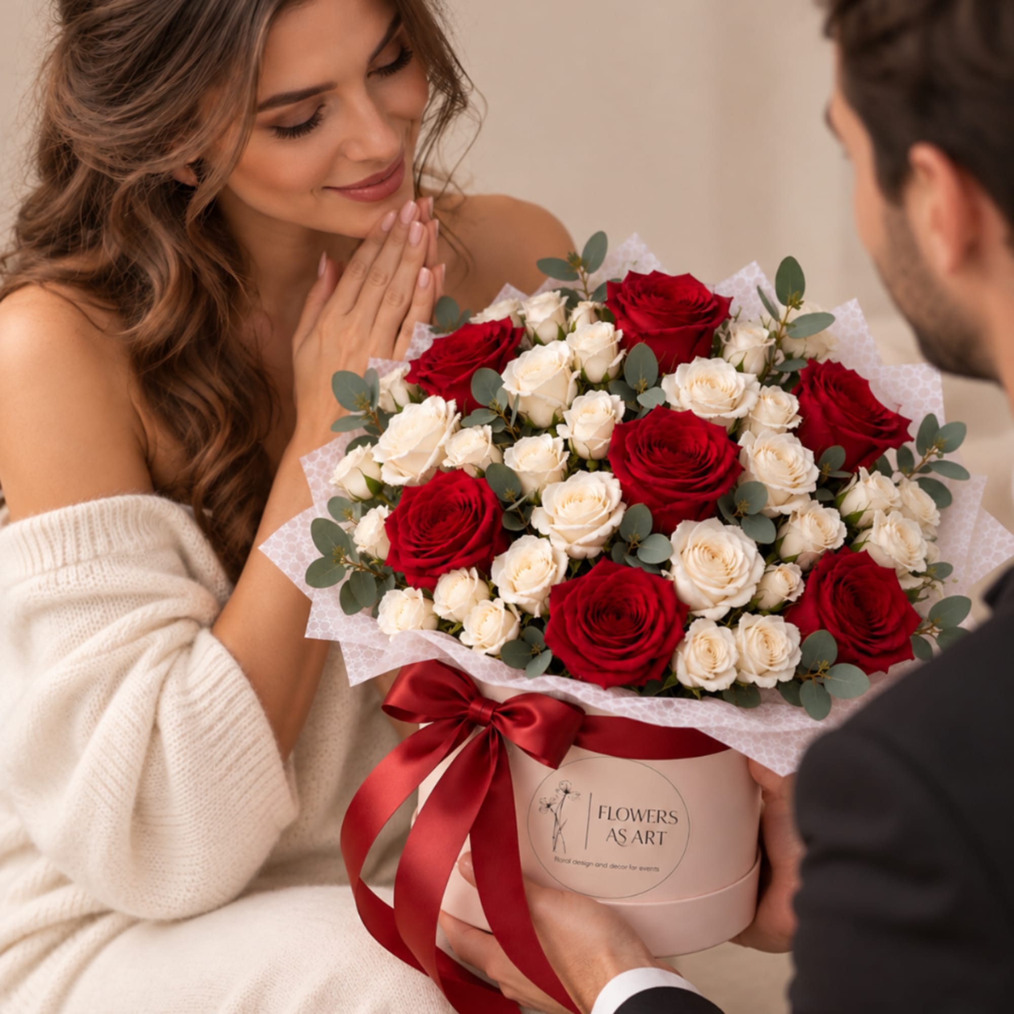 Red and white rose bouquet in a pink hatbox with a red ribbon