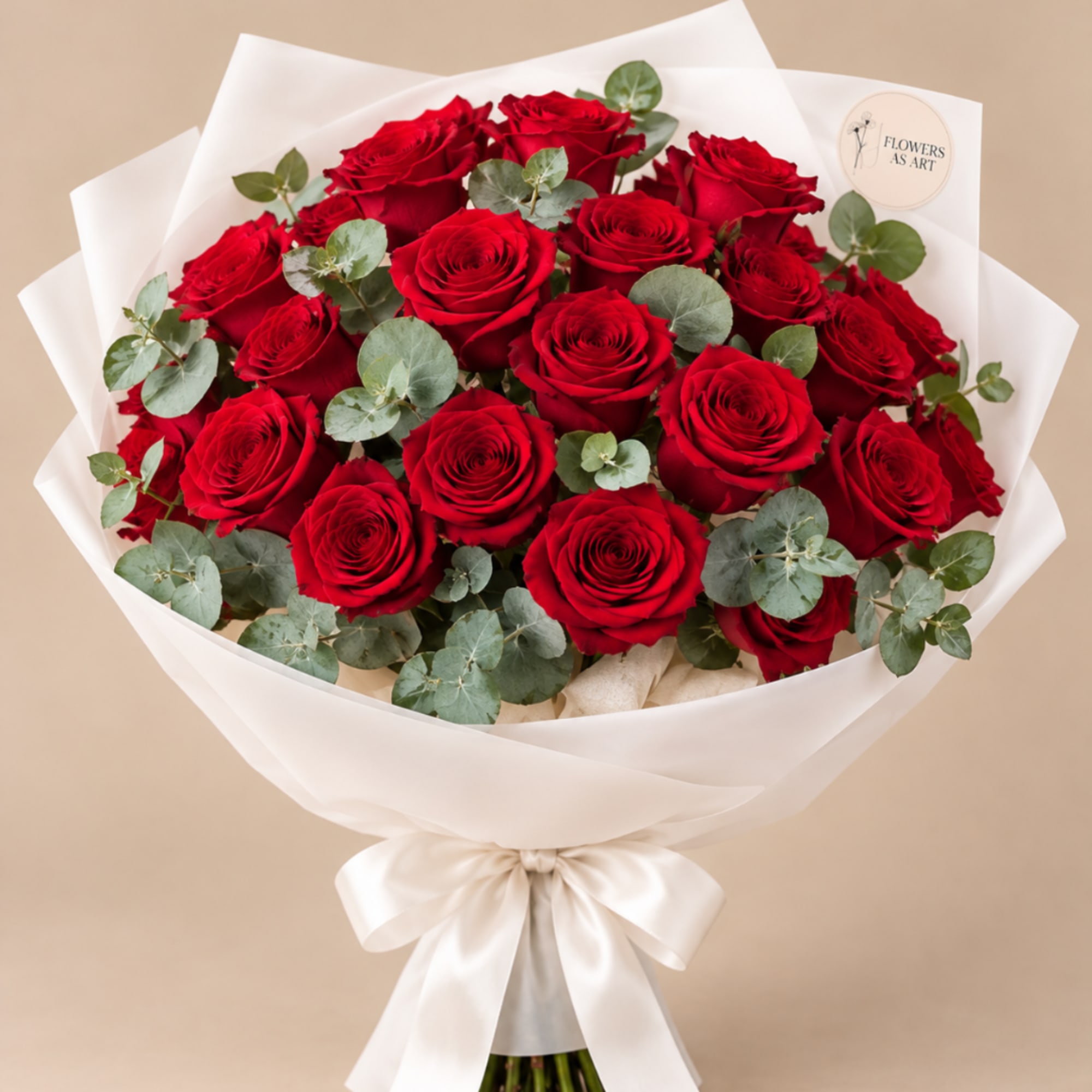 Bouquet of red roses wrapped in white paper with a satin bow