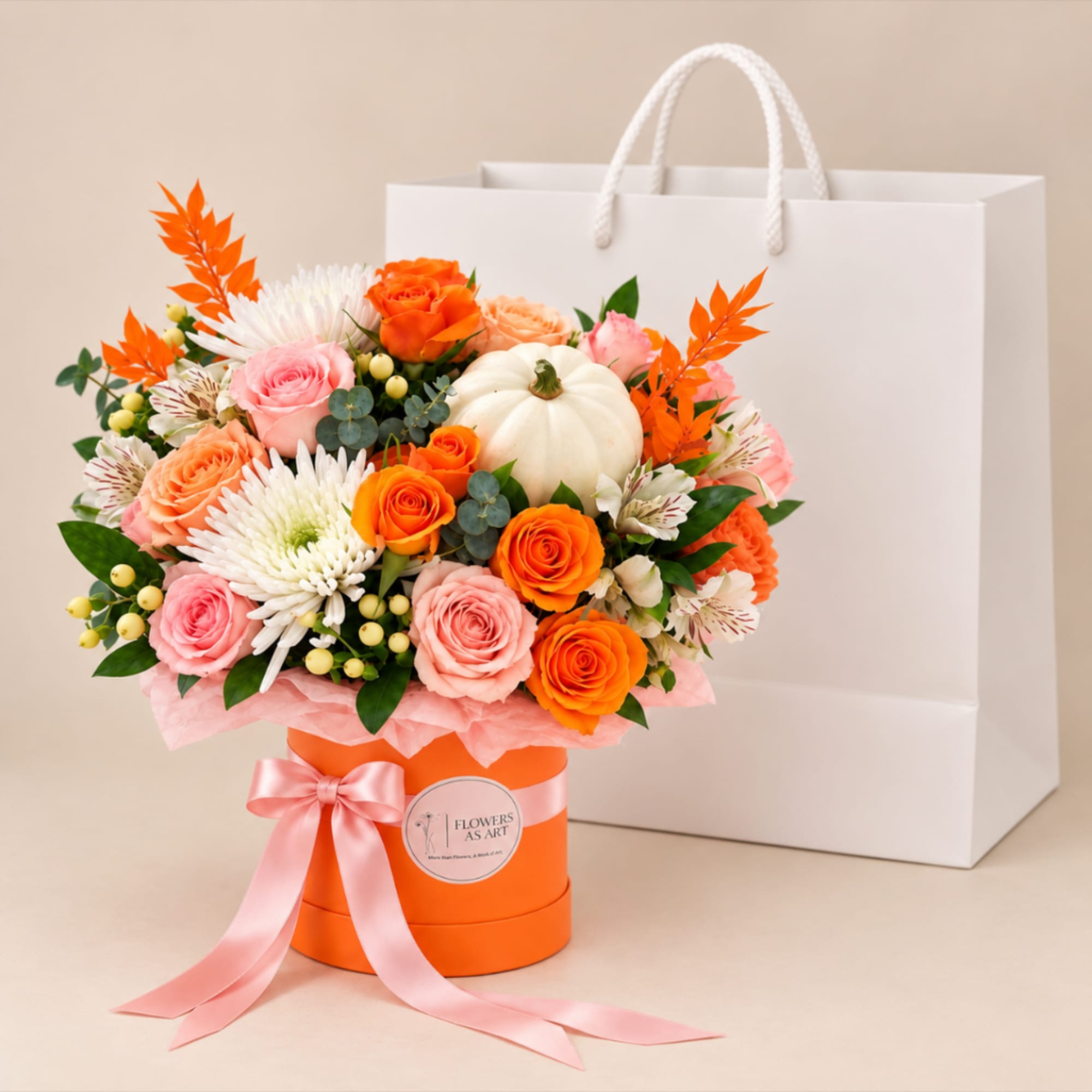 Orange and pink rose bouquet in a round box with a pink ribbon