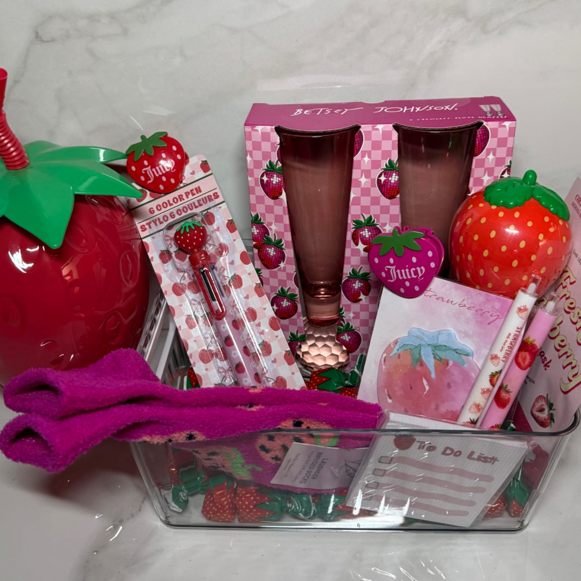 Strawberry-themed gift basket with tumblers, pens, and a notepad