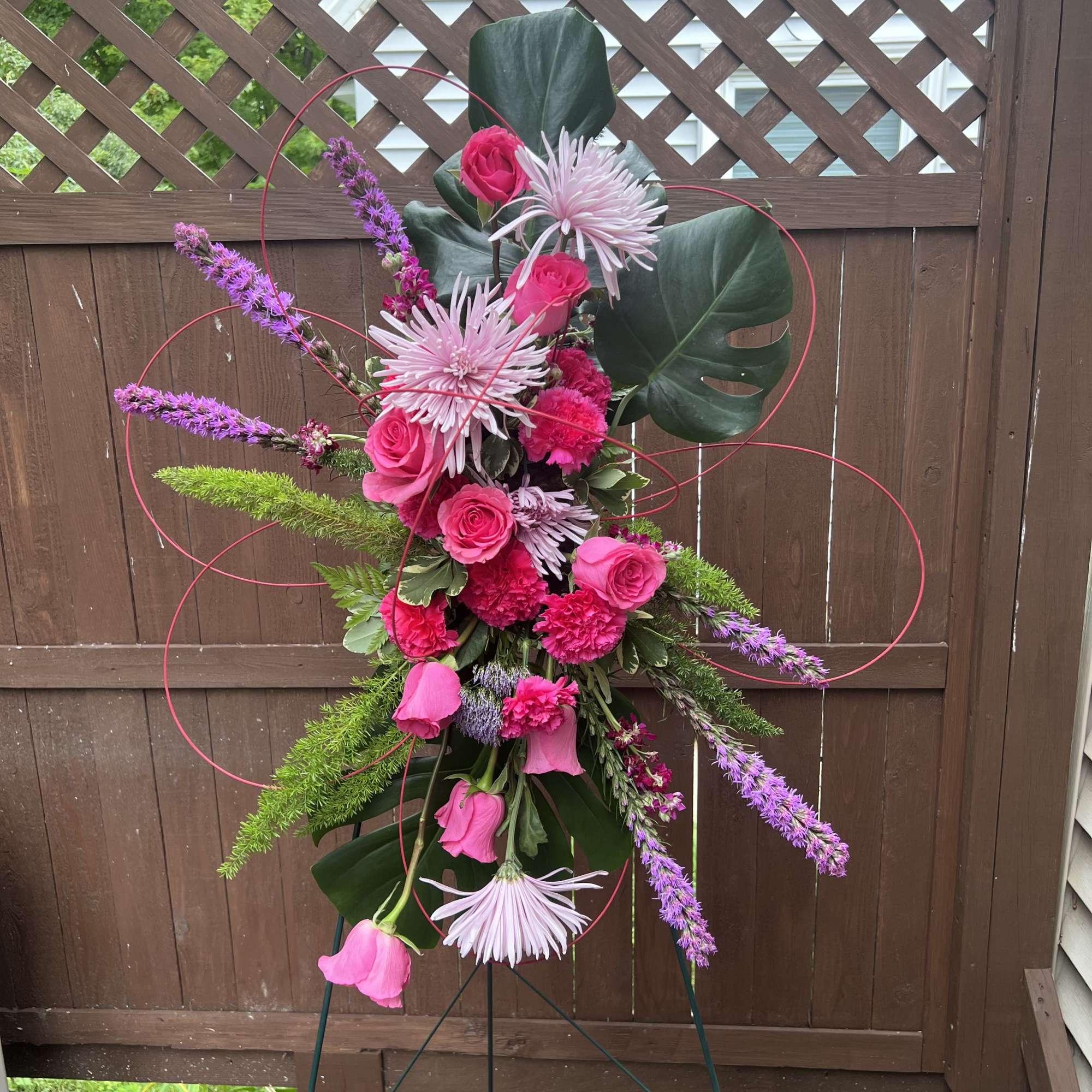 This lovely floral tribute design, a standing spray featuring vibrant pink and