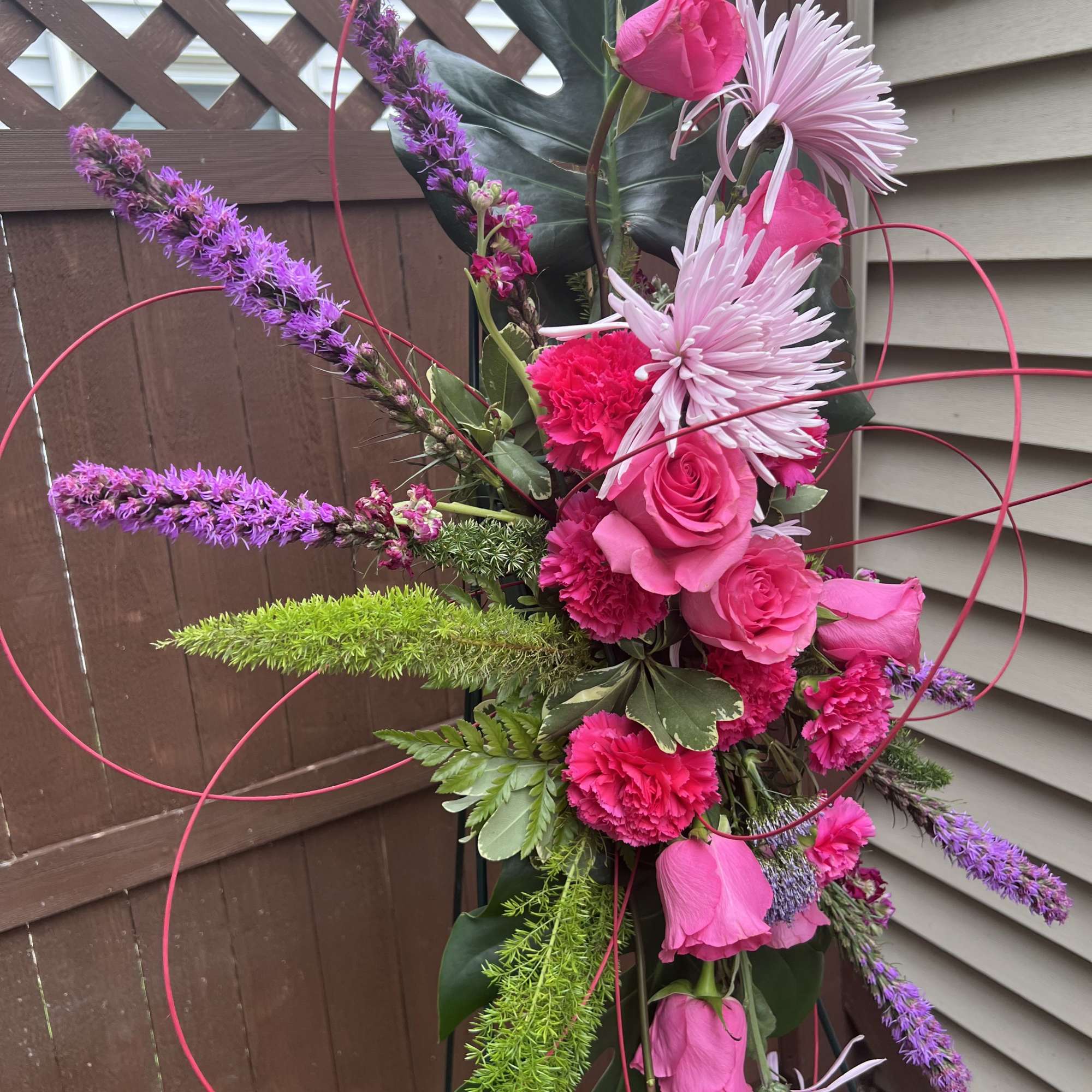 This lovely floral tribute design, a standing spray featuring vibrant pink and, photo 2 of 2