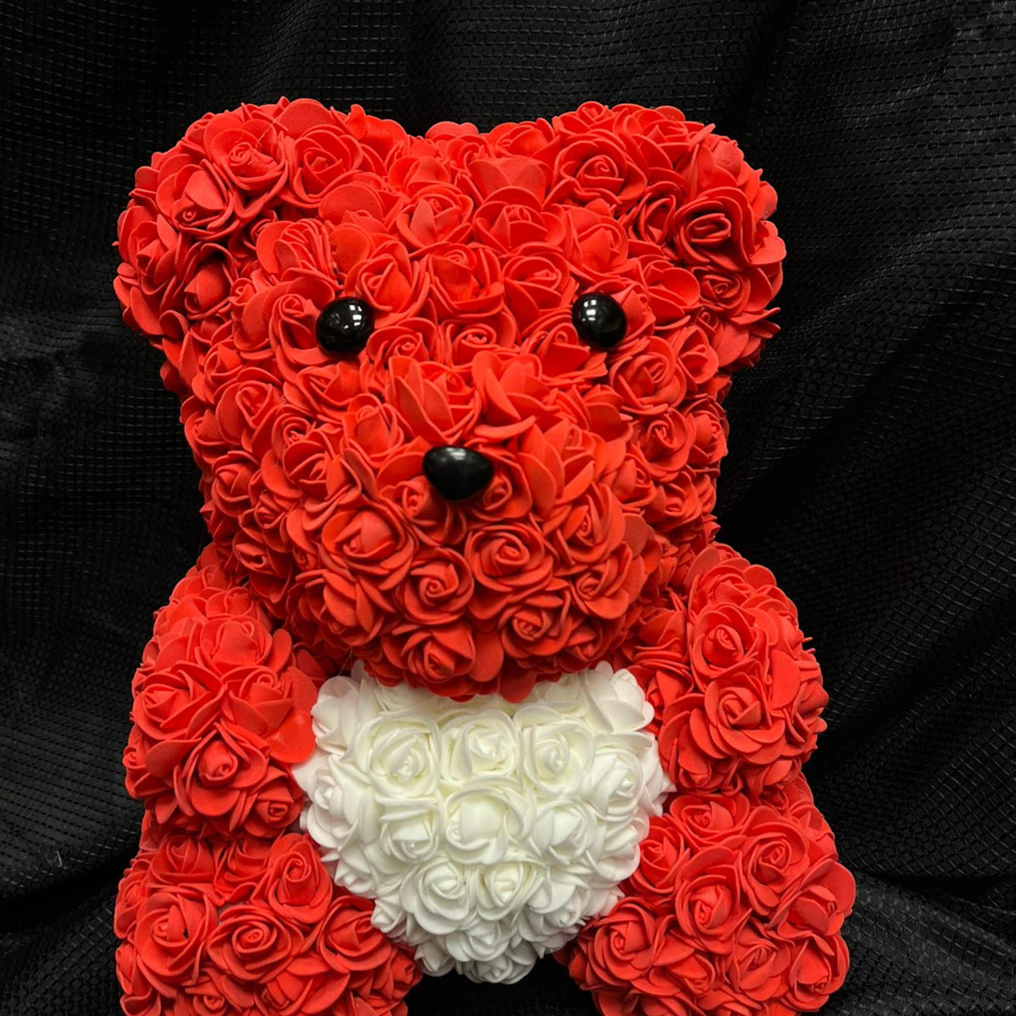 Red rose teddy bear with a white heart on its chest