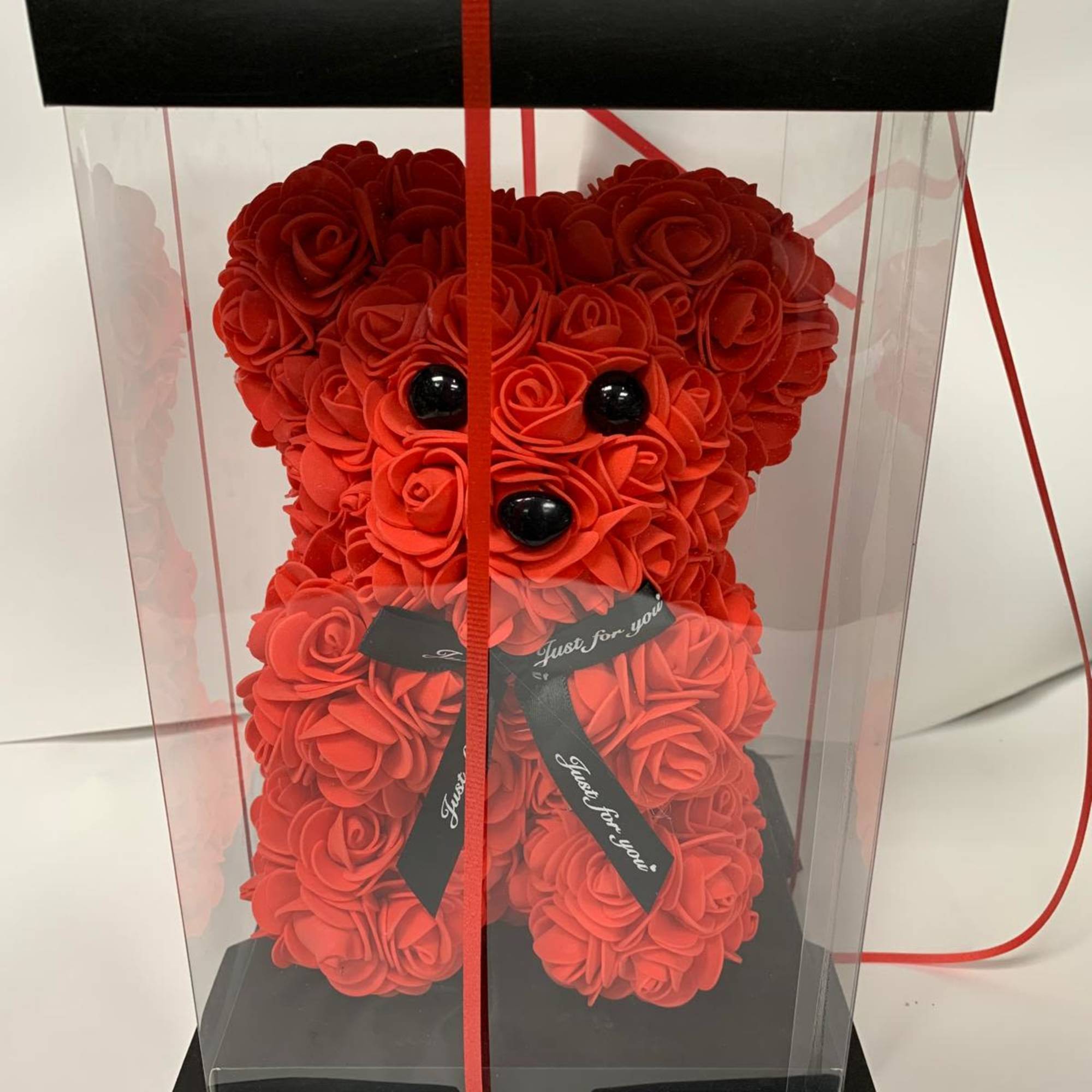 Red rose teddy bear in a clear gift box with a ribbon