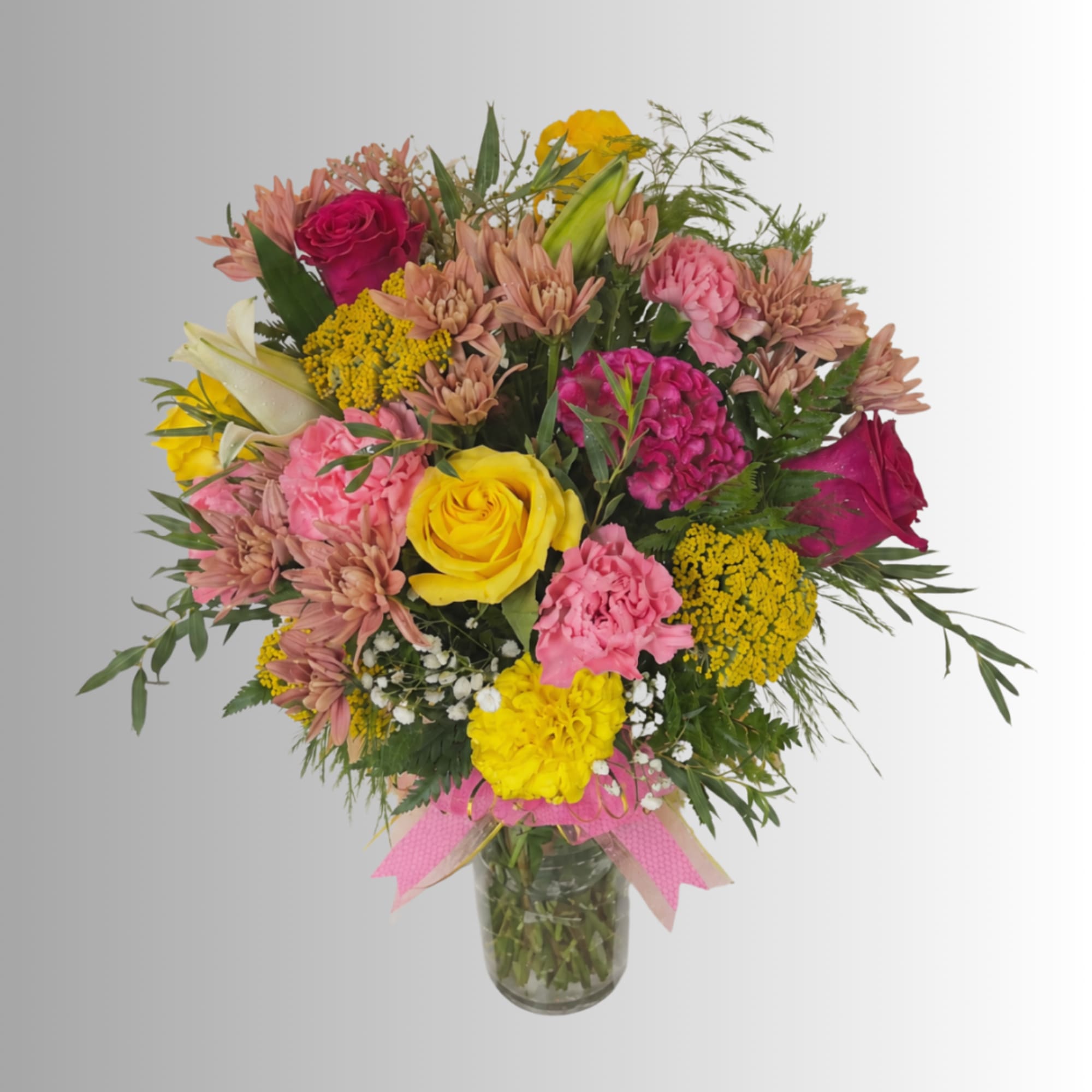 Mixed bouquet of roses, carnations, and mums in a glass vase