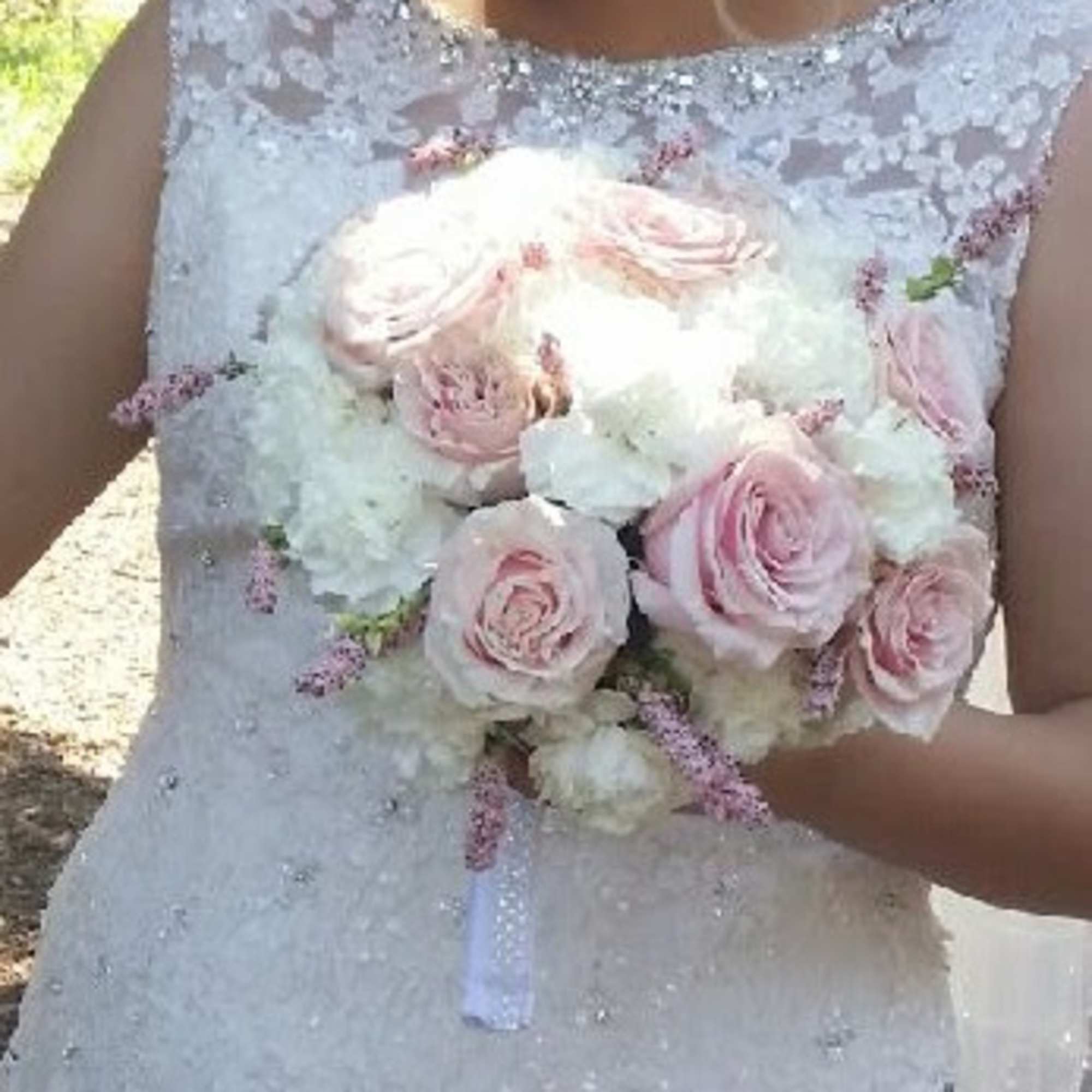 Bride holding a bouquet of pale pink roses and white flowers