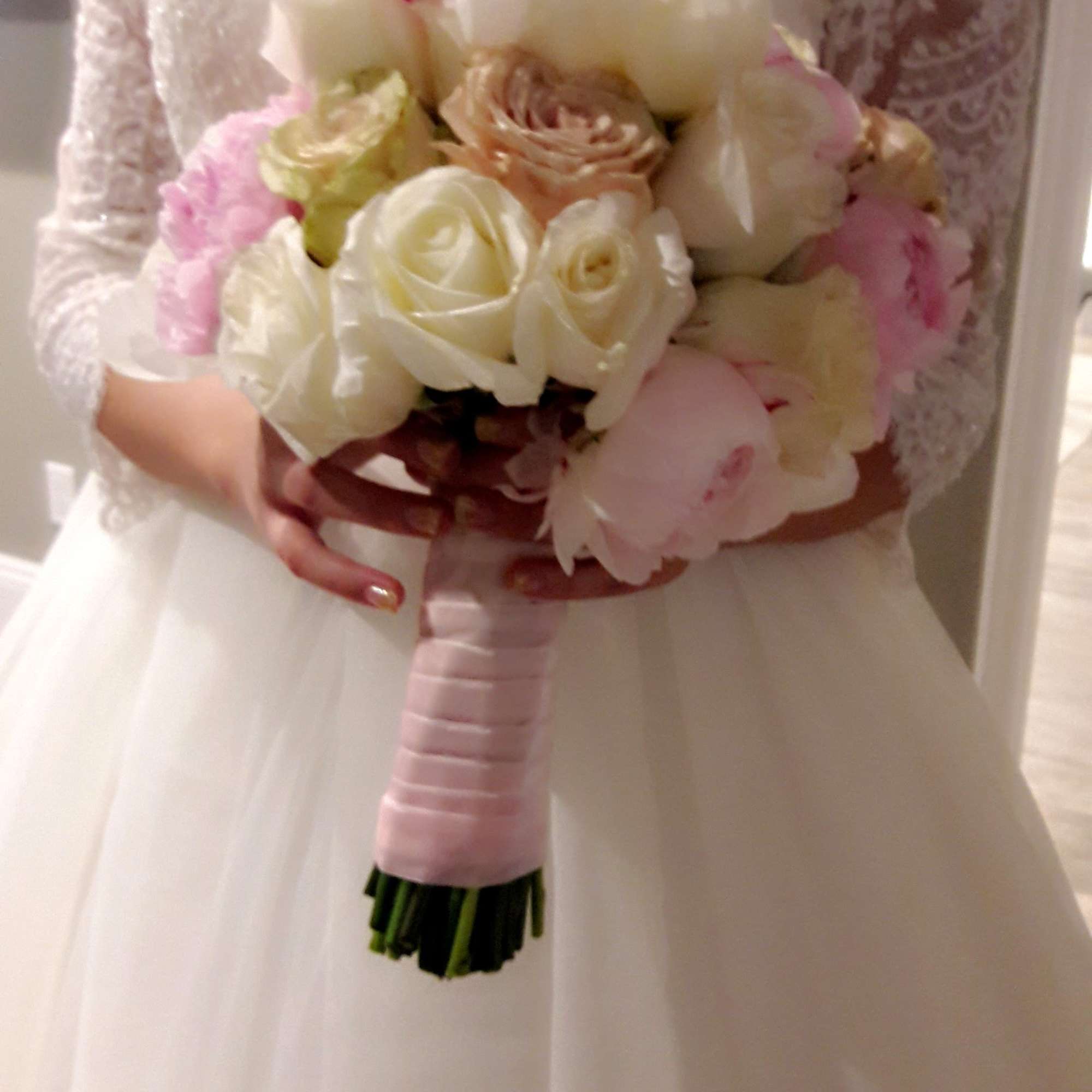 Bride holding a bouquet of white and blush flowers