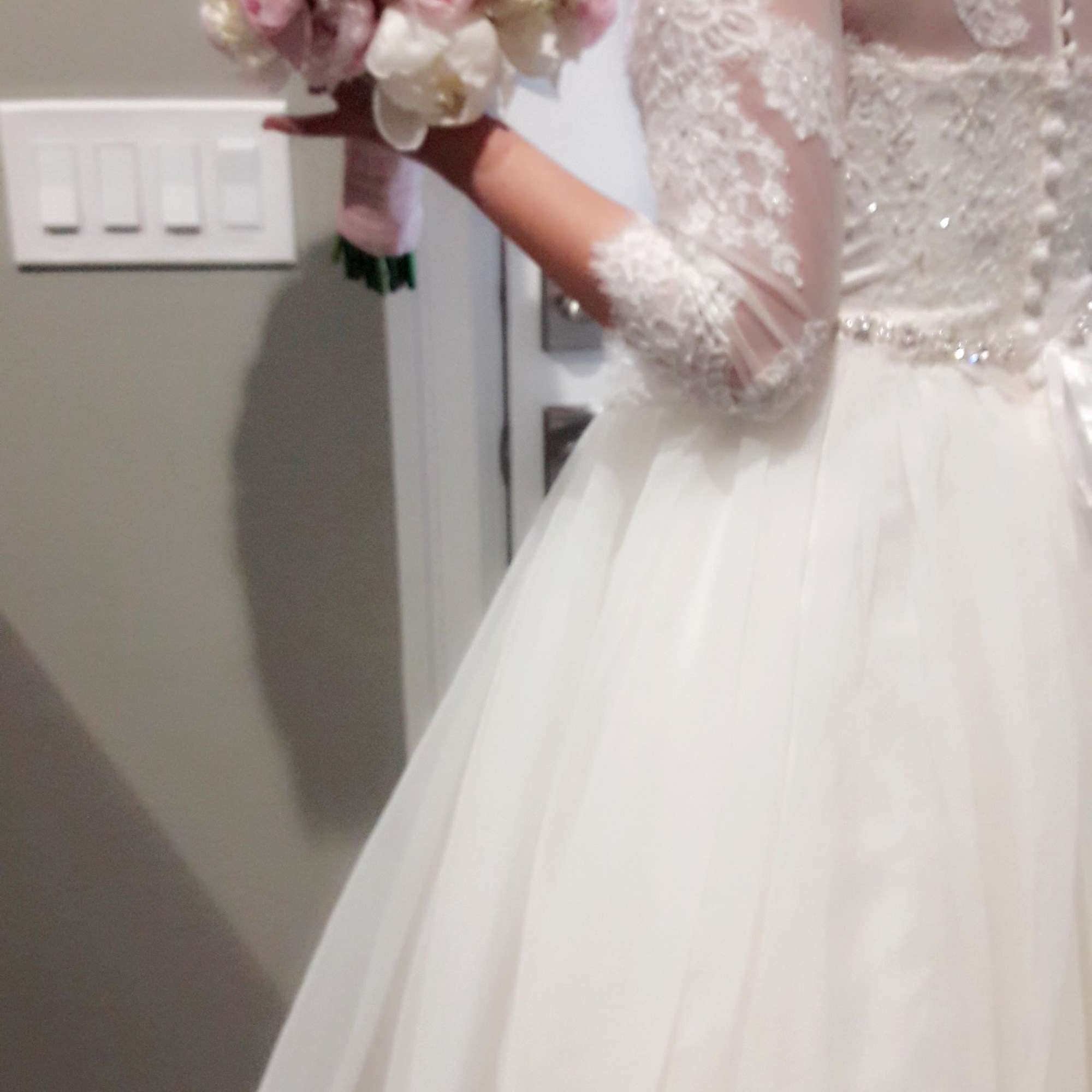 Bride holding a bouquet of pale pink and white roses