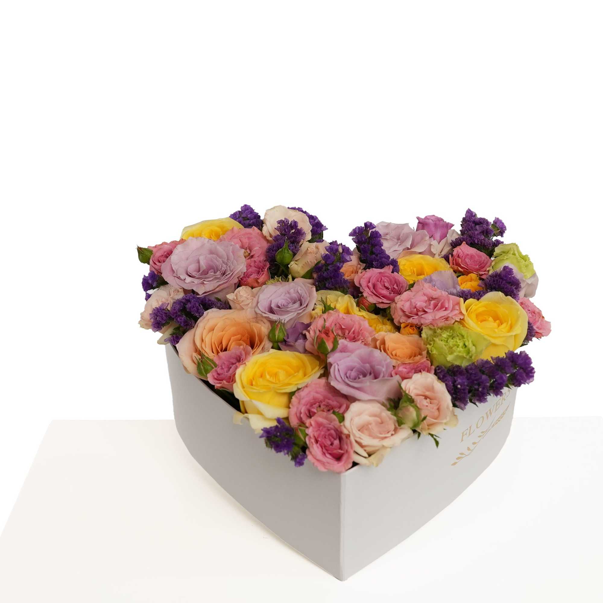 Heart-shaped box filled with pastel roses and purple flowers
