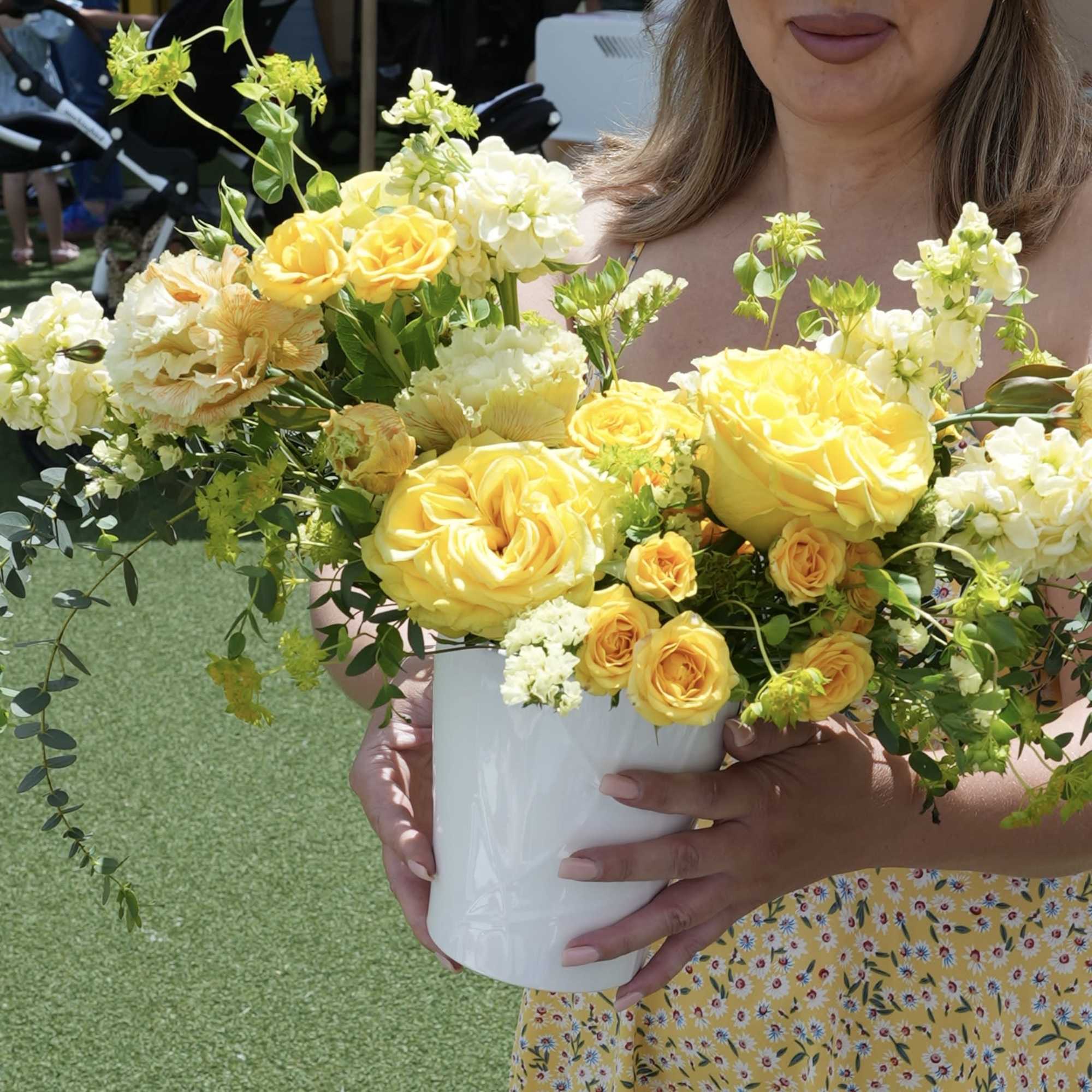Yellow and white rose arrangement in a white vase