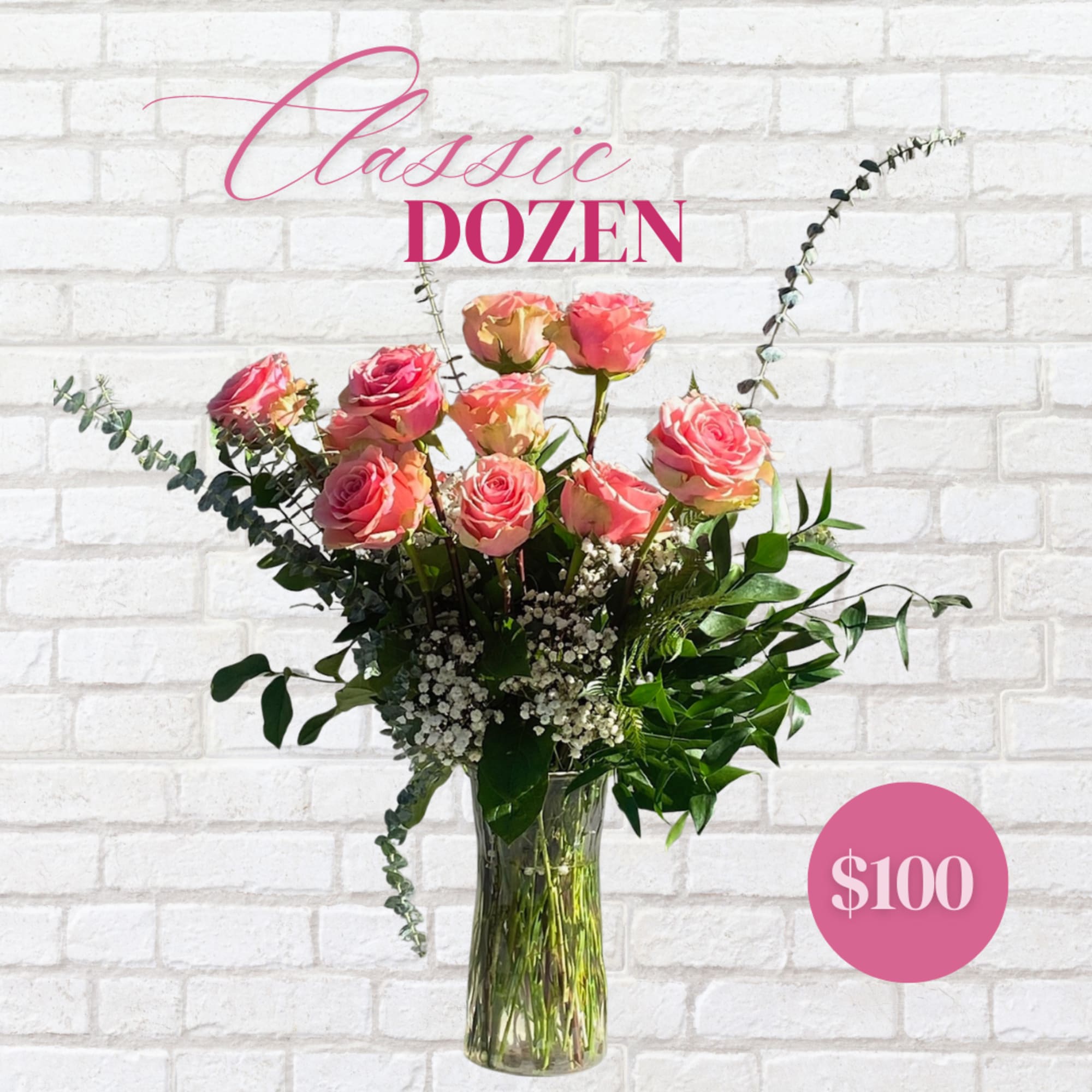 Pink roses arranged in a clear glass vase with greenery