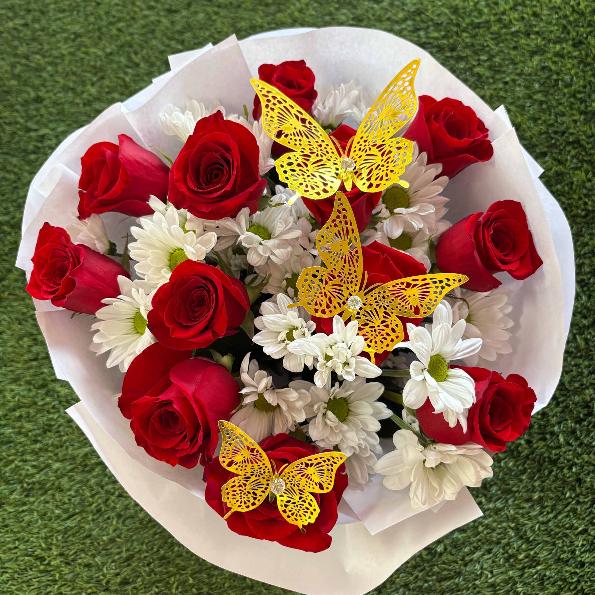 Bouquet of red roses and white daisies with yellow butterfly decorations