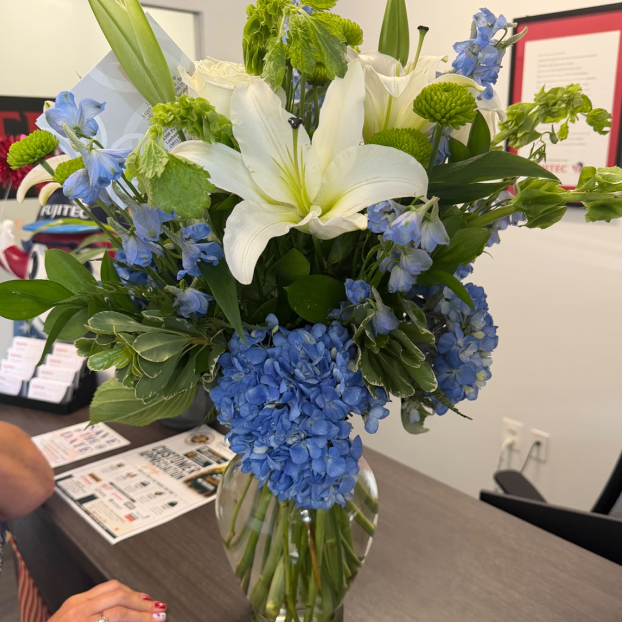 Blue and white flower arrangement in a clear glass vase, photo 3 of 4