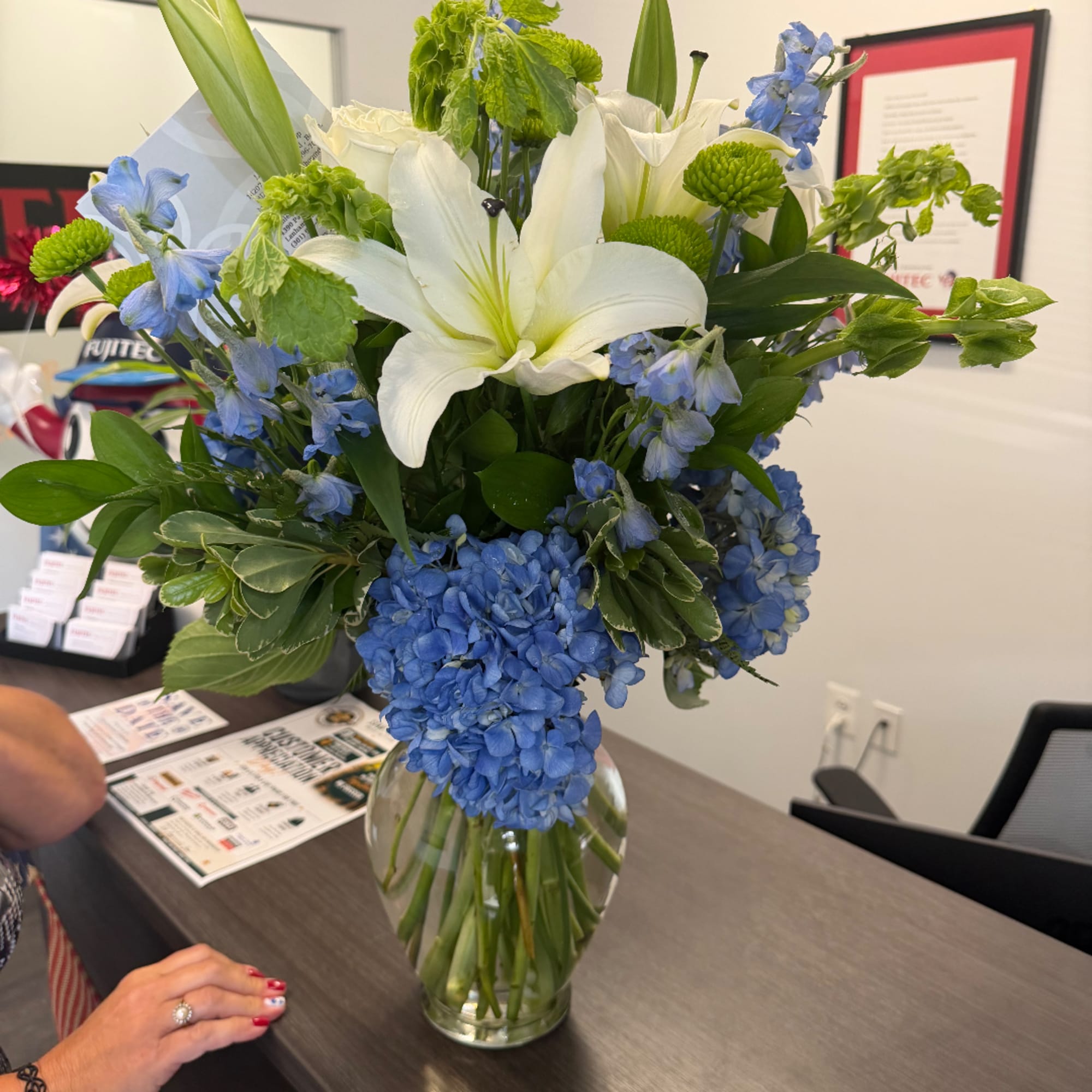Blue and white flower arrangement in a clear glass vase, photo 4 of 4