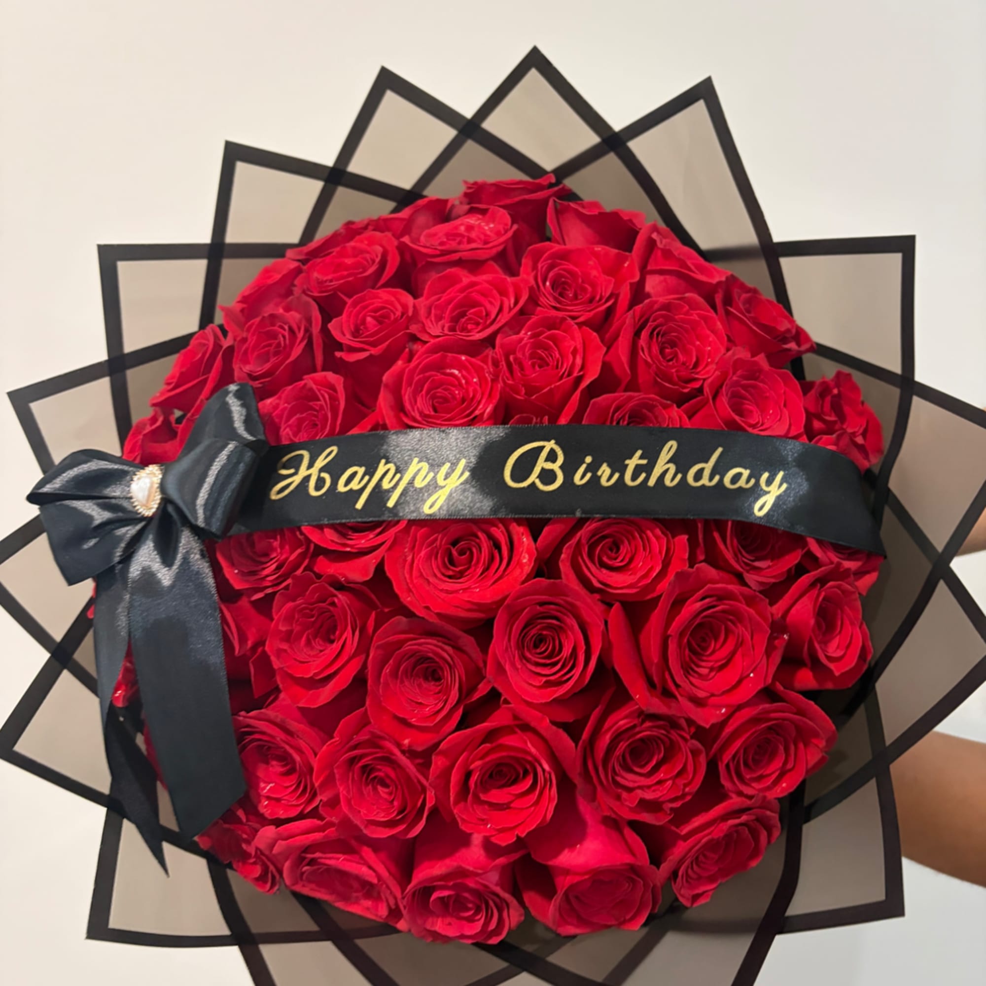 Bouquet of red roses with a black birthday ribbon and bow