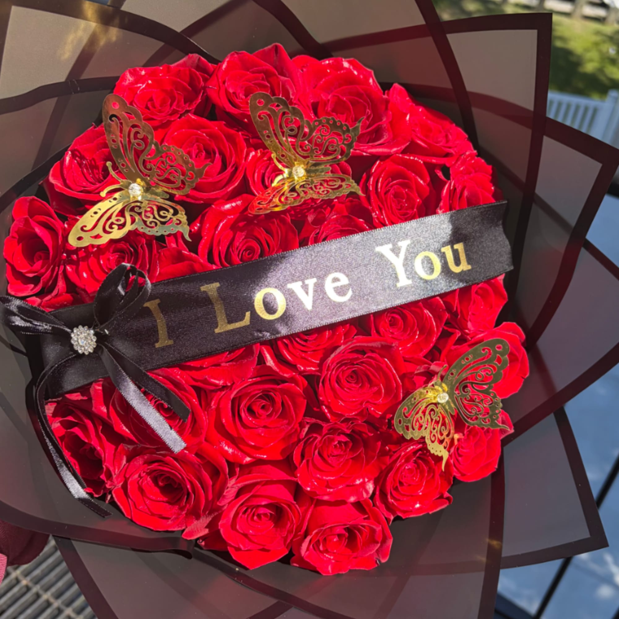 A dense, rounded bouquet of vivid red roses that reads like a