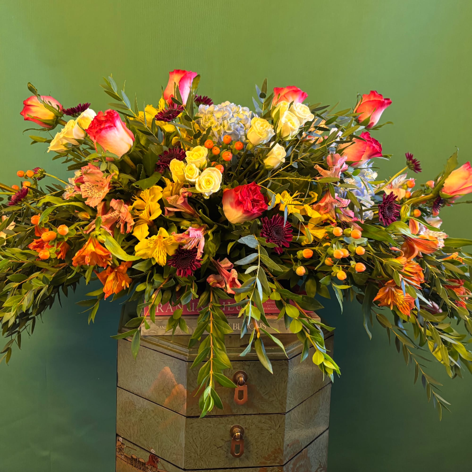 Large mixed bouquet with roses, alstroemeria, and berries in a decorative container