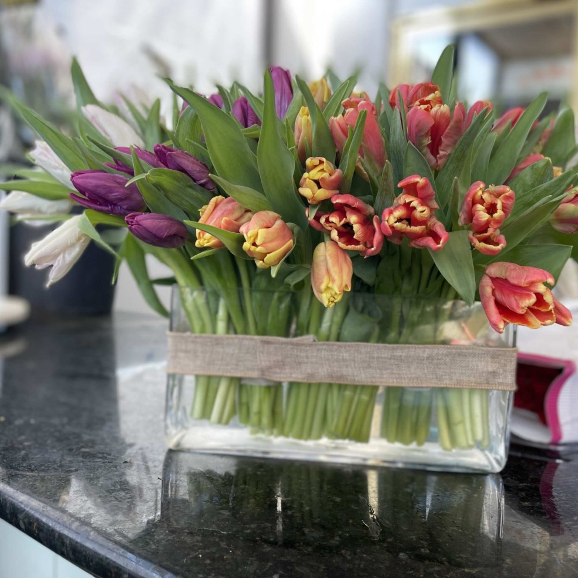 Bouquet of multicolored tulips in a rectangular glass vase