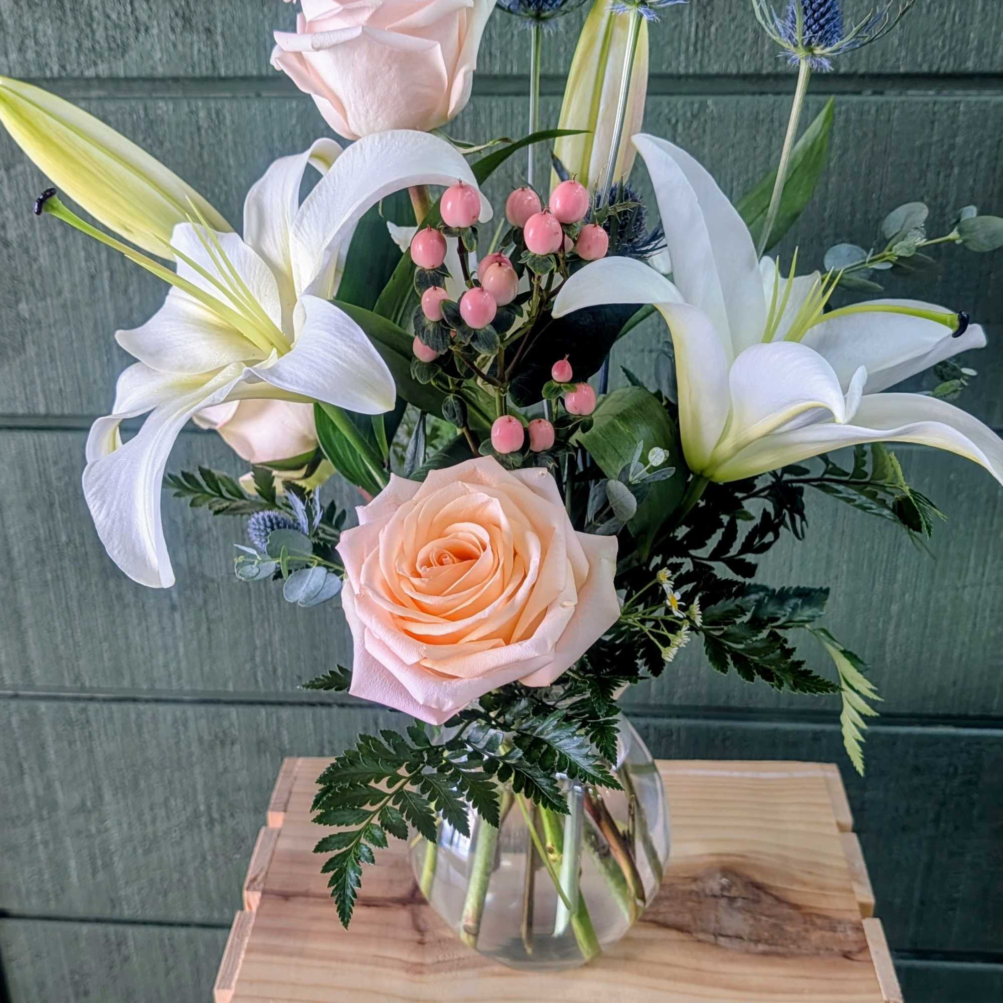 GLASS VASE INCLUDES LILIES, PEACH ROSES, HYPERICUM BERRY, THISTLE, EUCALYPTUS &amp; GREENS
