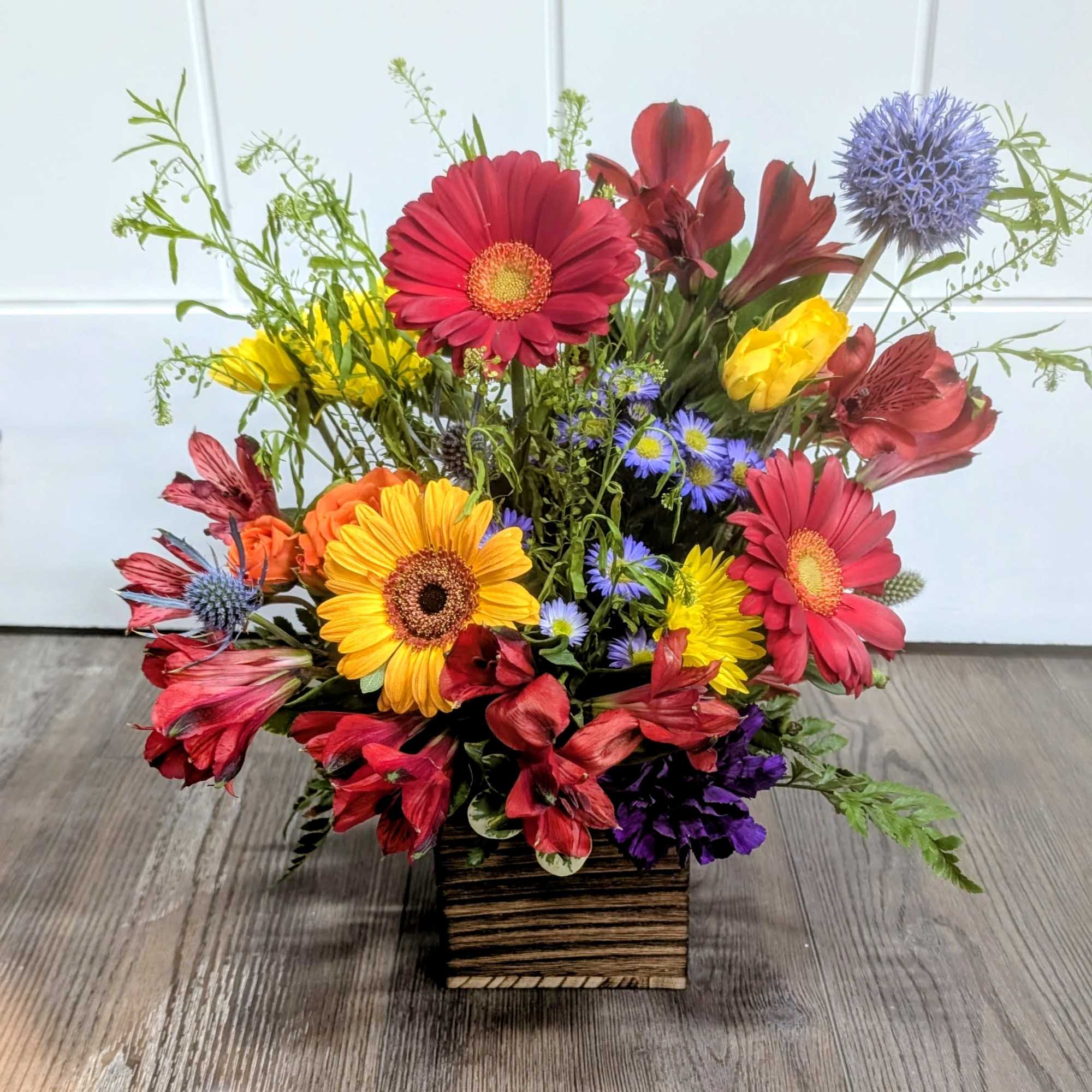 GERBERA DAISIES, ALSTROEMERIA AND PURPLE ASTERS IN REDS, YELLOWS, ORANGES AND PURPLES.