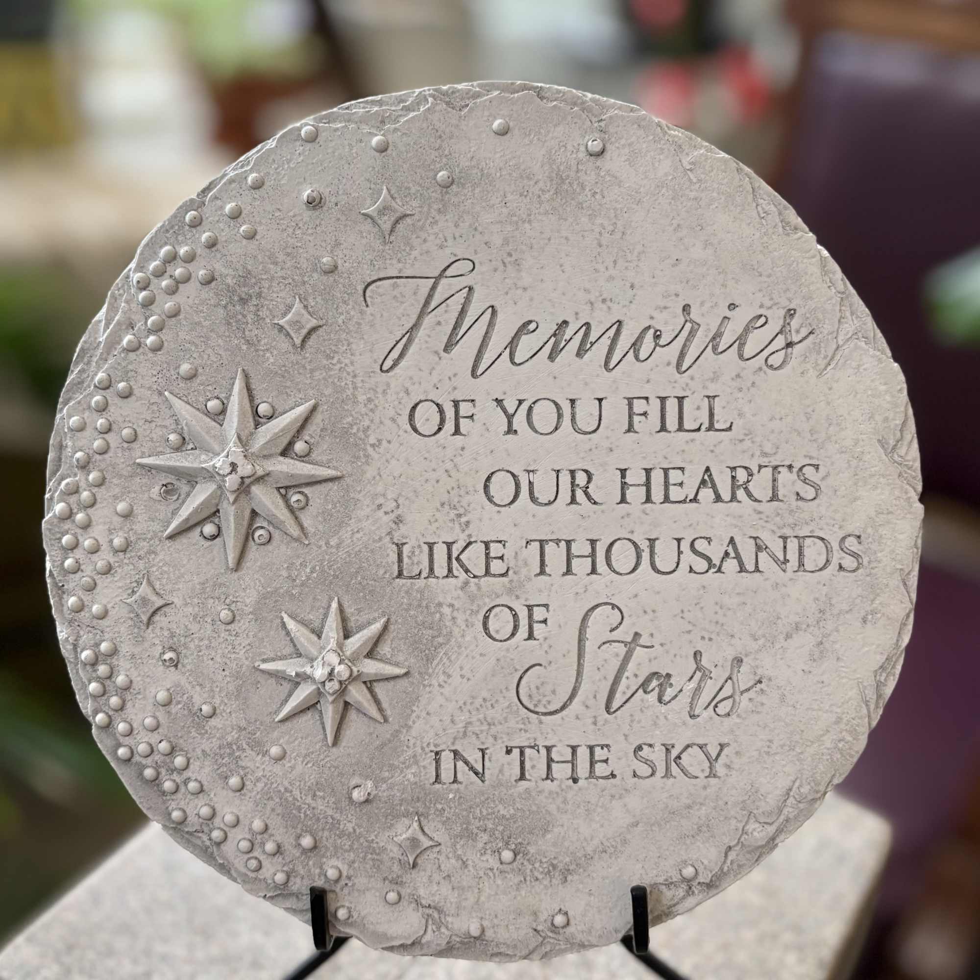 Circular stepping stone that reads, 
"Memories of you fill our hearts like