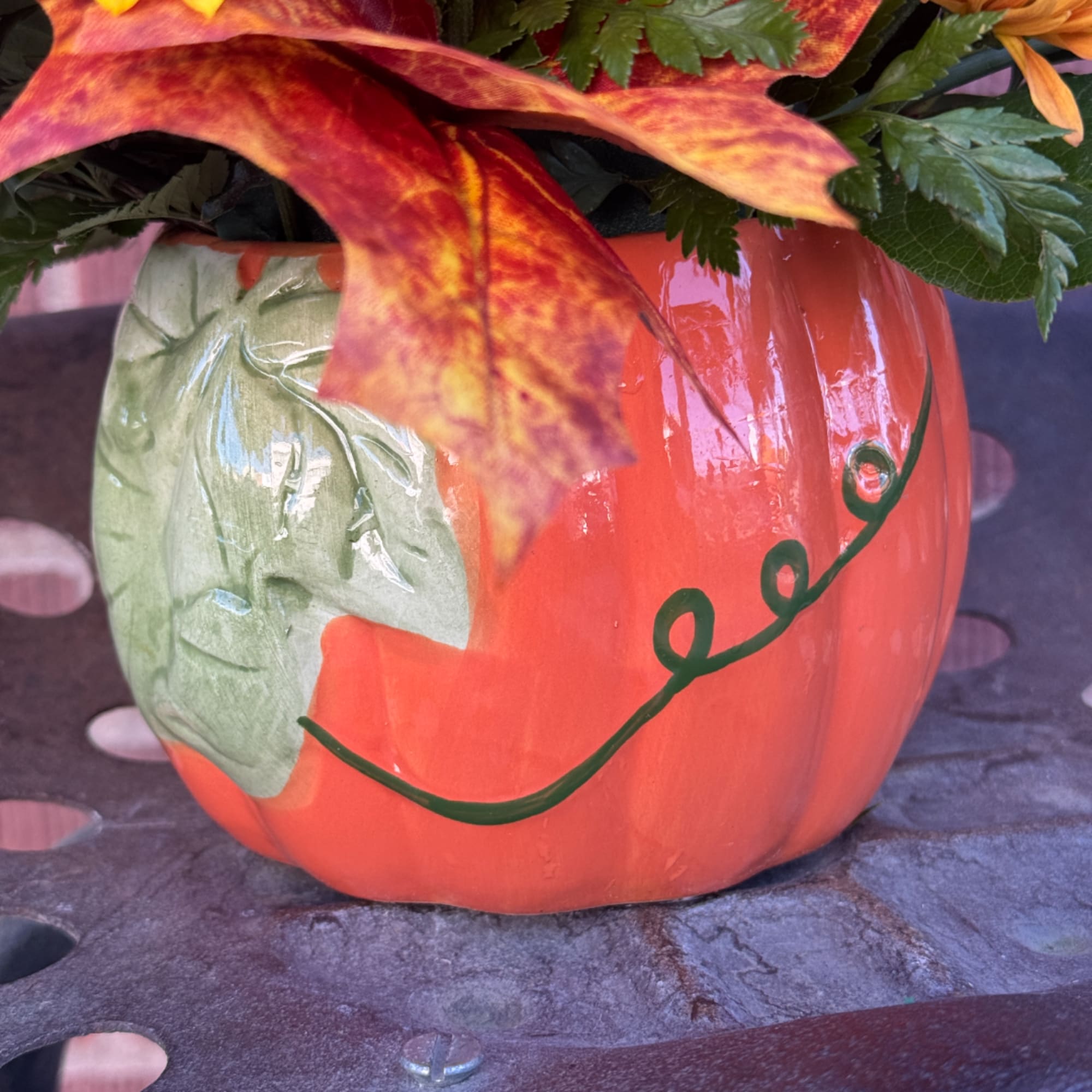 Painted pumpkin vase with autumn flowers and leaves