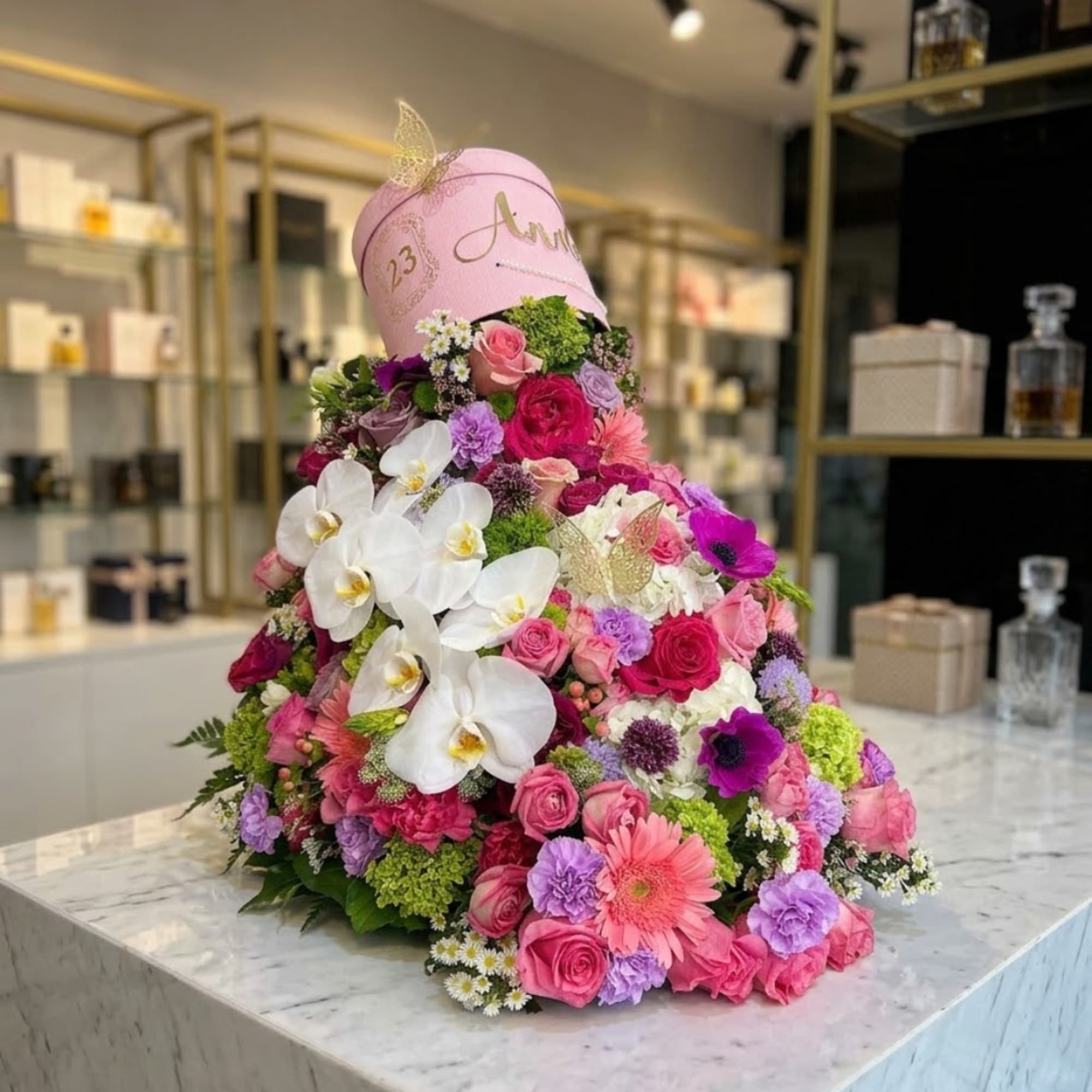 Large pink floral arrangement with white orchids and roses in a pink hatbox, photo 2 of 6