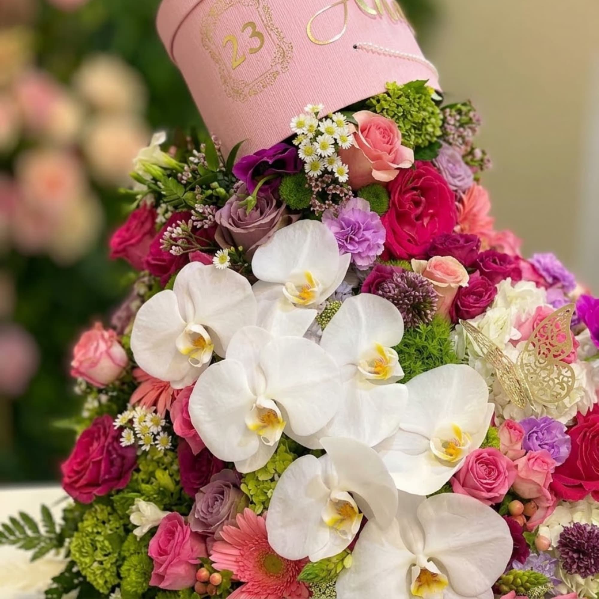Pink hatbox arrangement with white orchids and mixed roses
