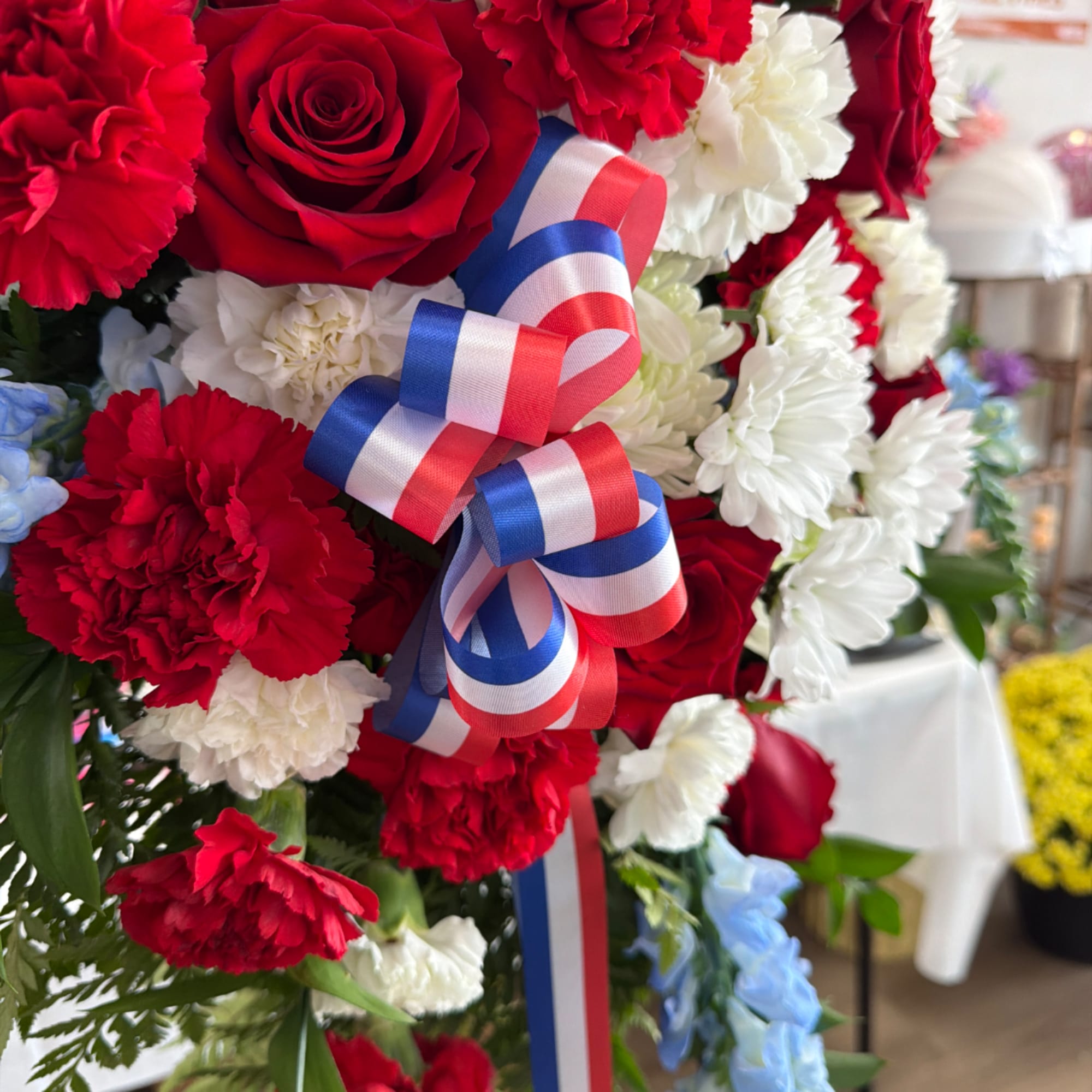 Red, white, and blue floral arrangement with a ribbon bow