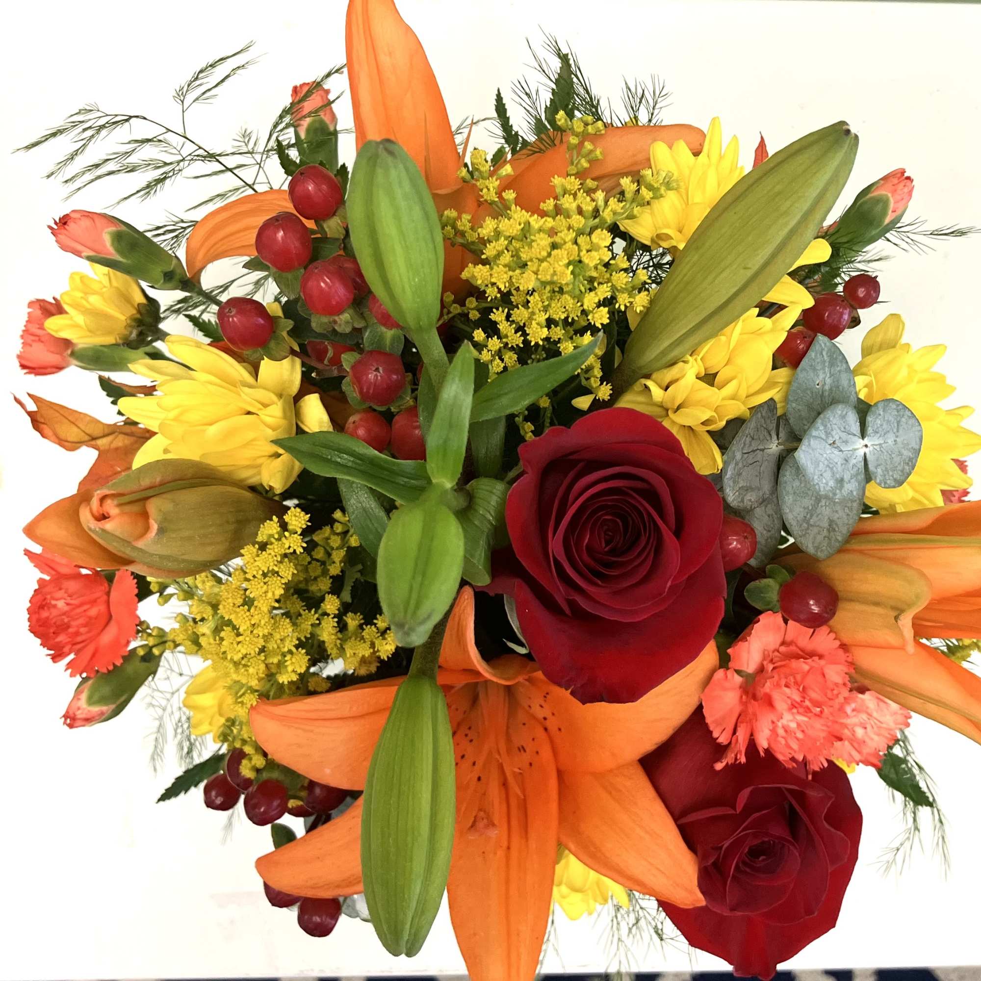 Bouquet of red roses, orange lilies, and yellow flowers