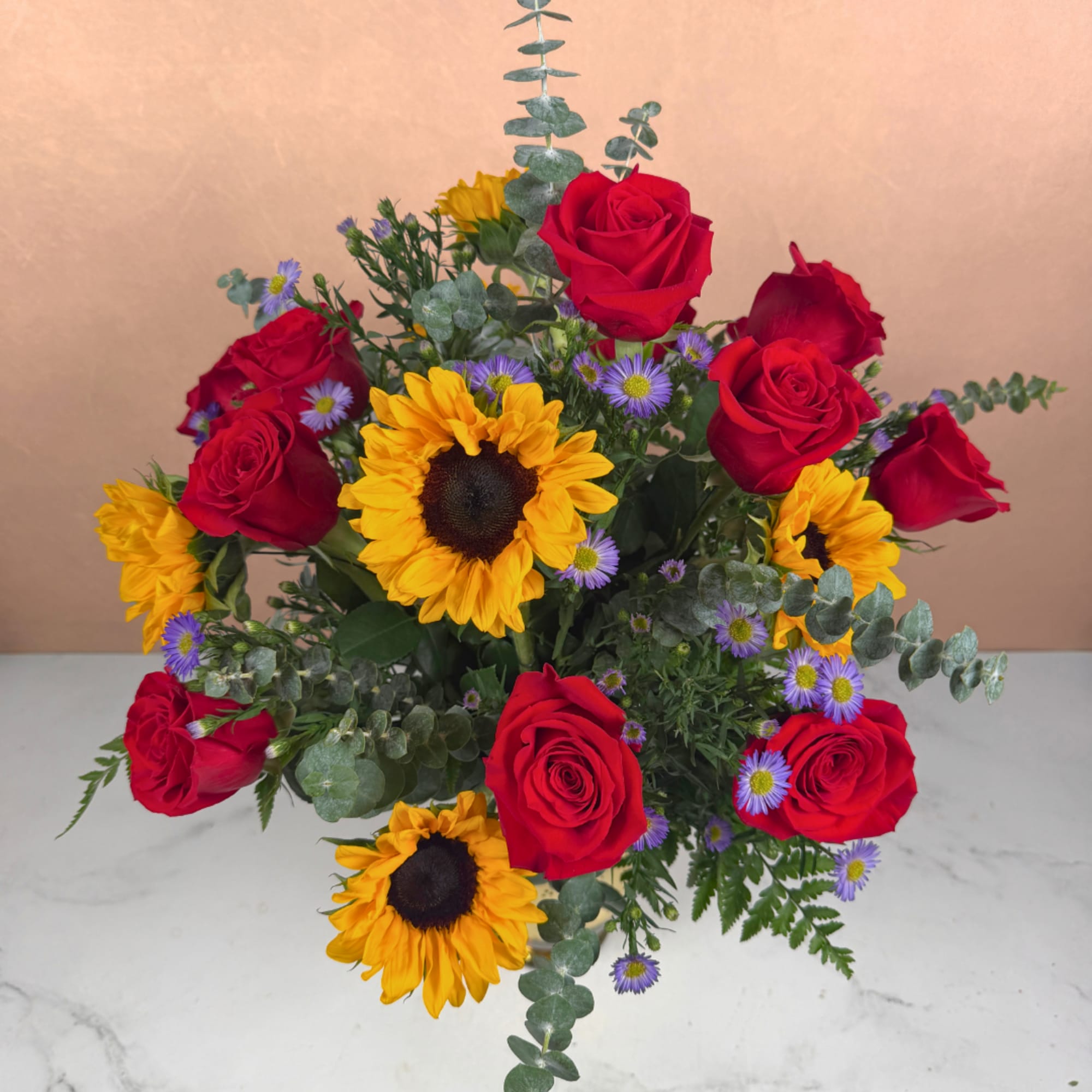 Bouquet of red roses and sunflowers with small purple daisies
