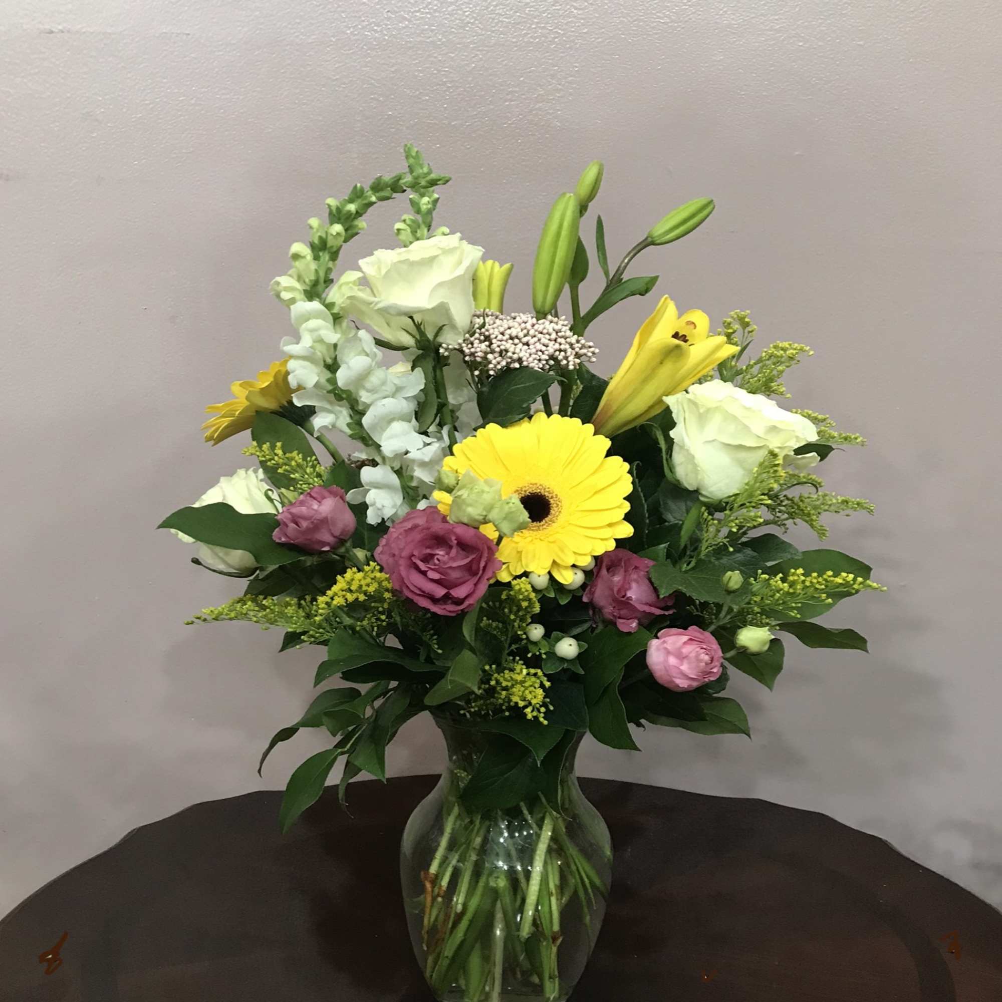 Mixed bouquet in a glass vase with yellow, white, and pink flowers