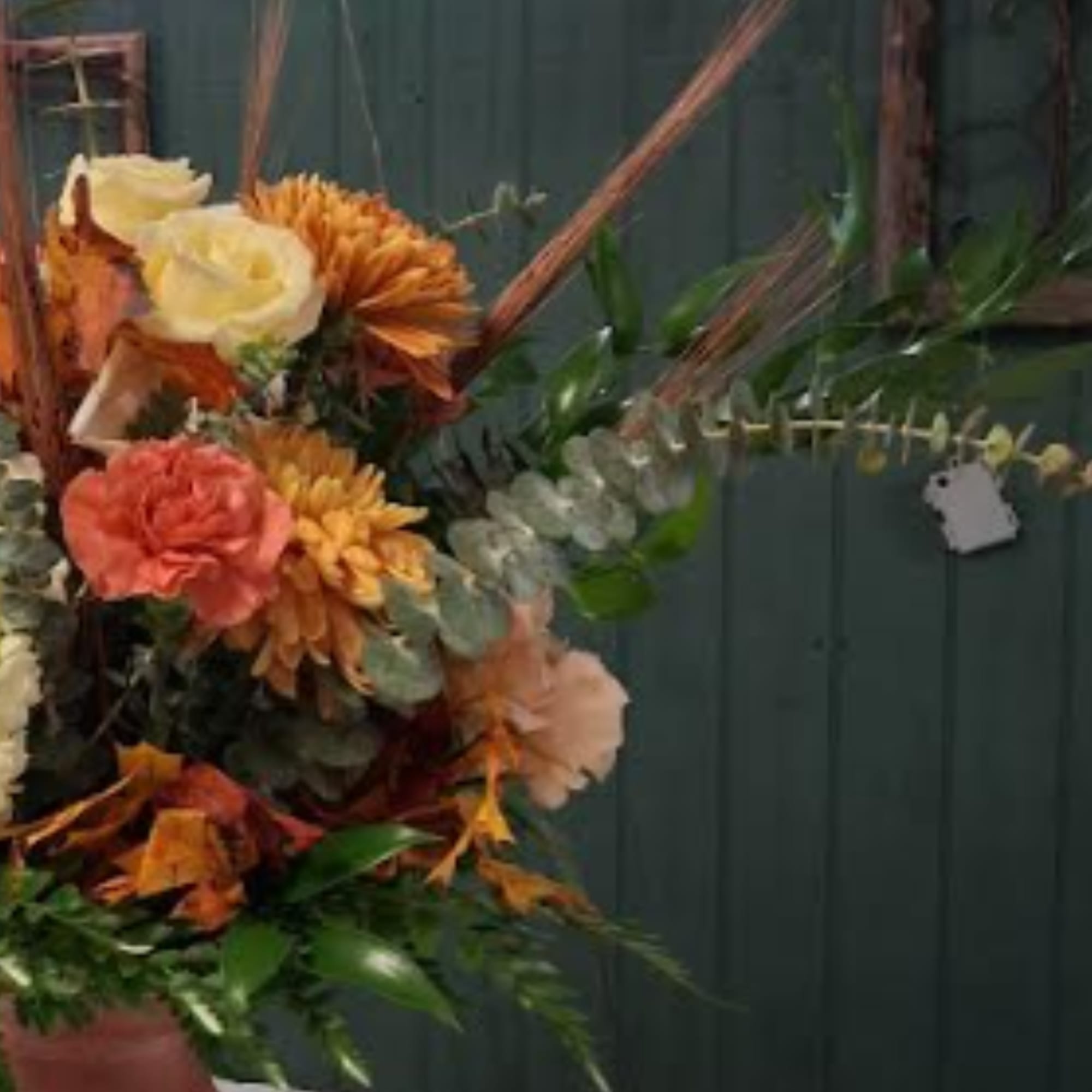 Autumn floral arrangement with roses and mums in warm tones