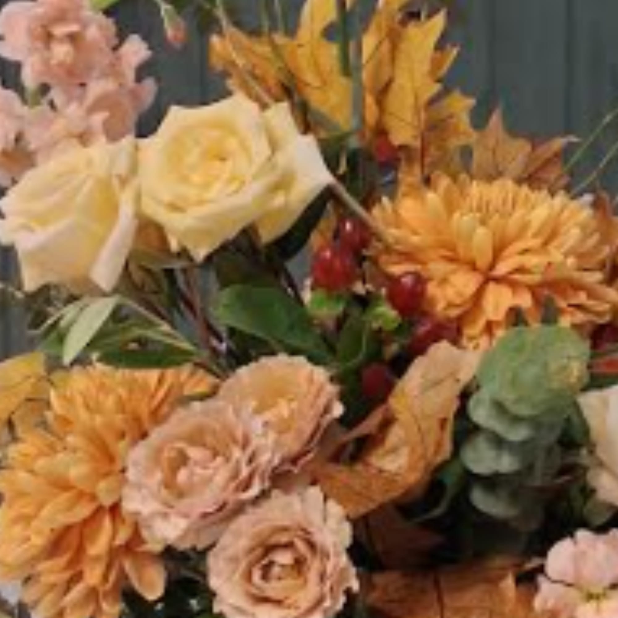 Bouquet of cream roses, peach flowers, and orange mums