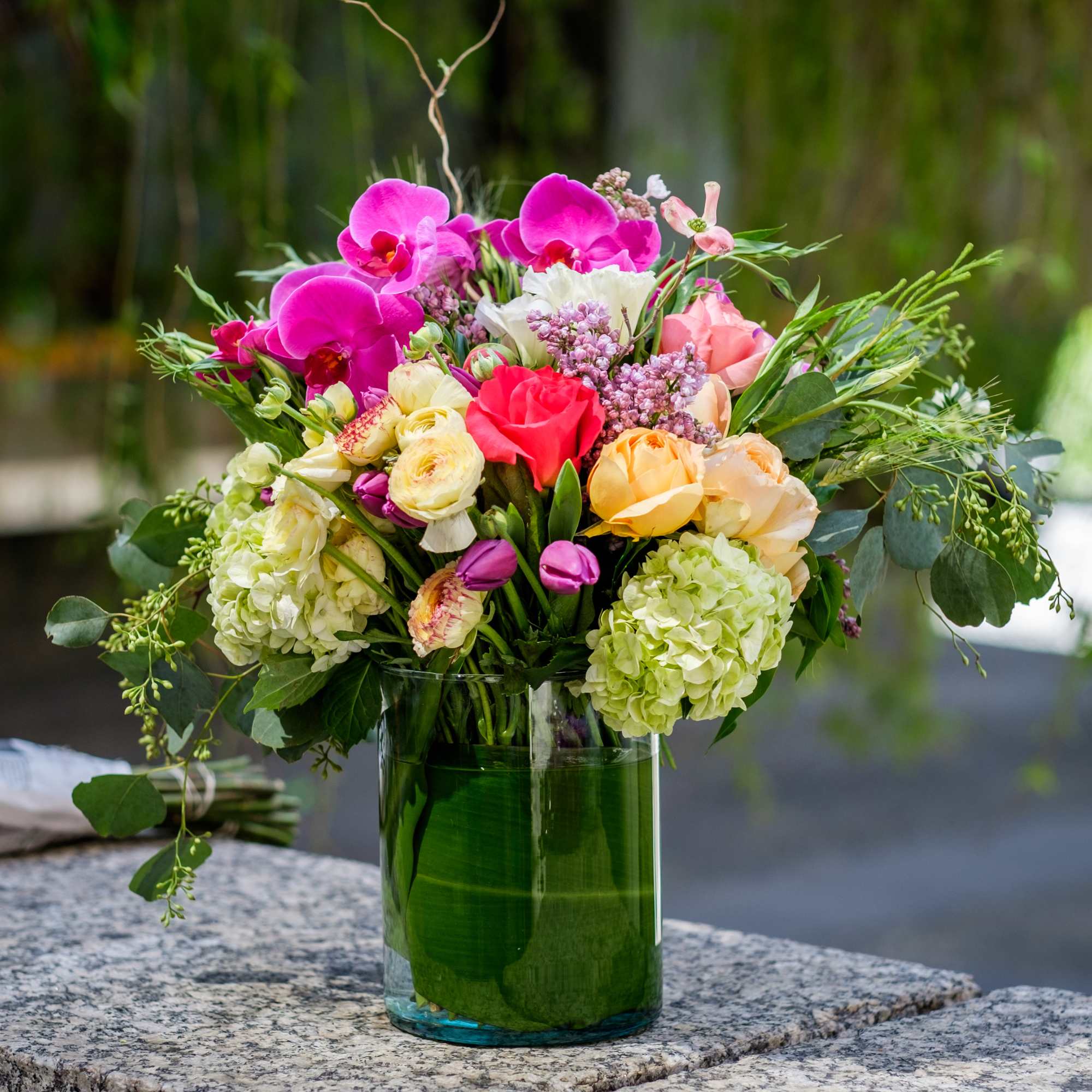 Mixed bouquet of orchids, roses, and hydrangeas in a glass vase, photo 2 of 2