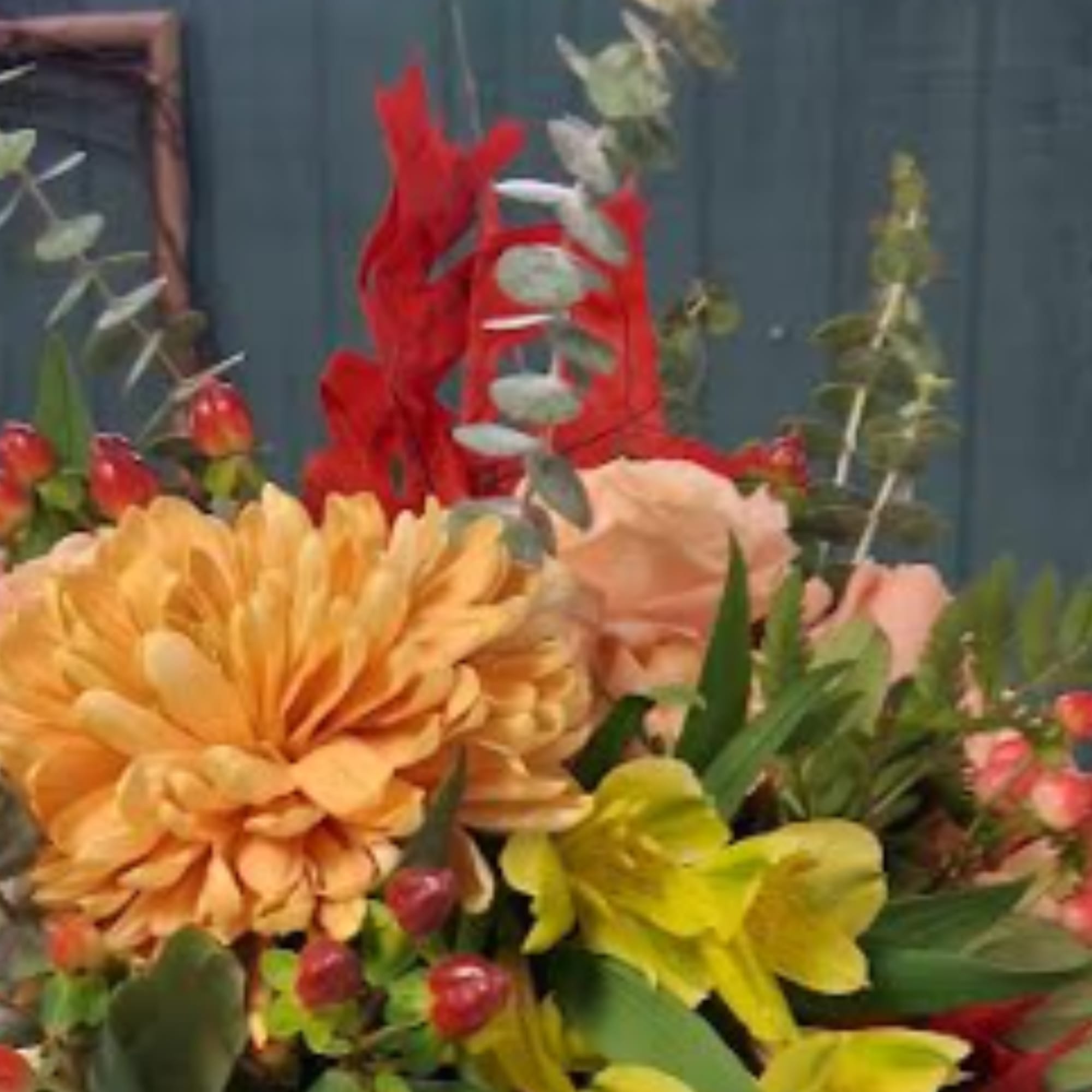 Bouquet with orange and yellow flowers and red accents