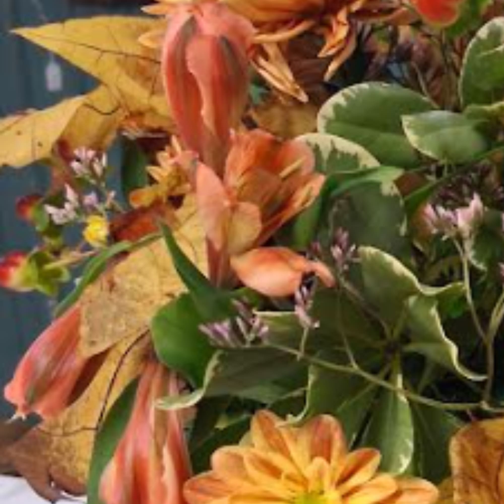 Autumn bouquet with orange lilies and yellow leaves