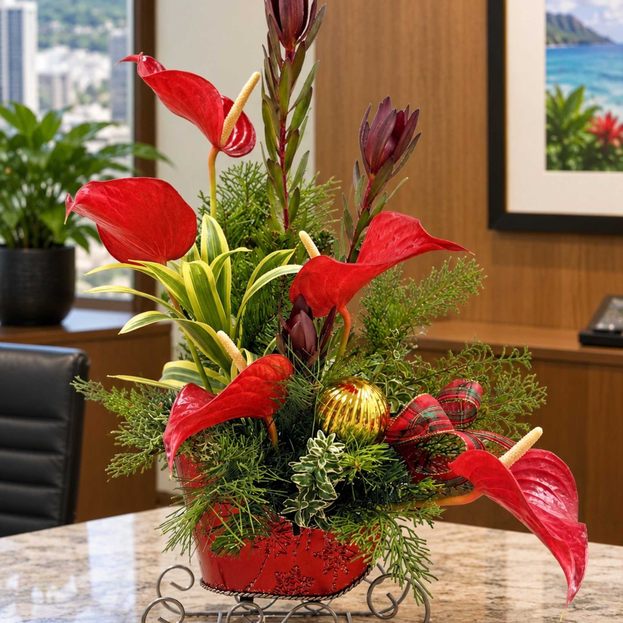 Red anthurium arrangement in a red container with a plaid ribbon