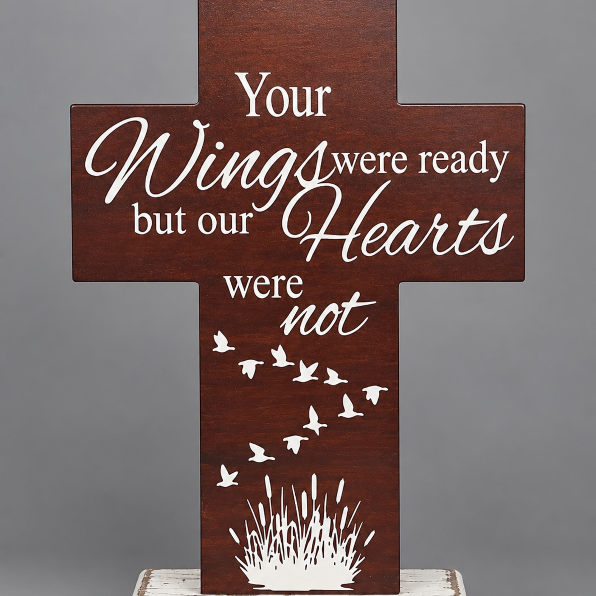 Wooden cross sign with a sympathy message and bird silhouettes