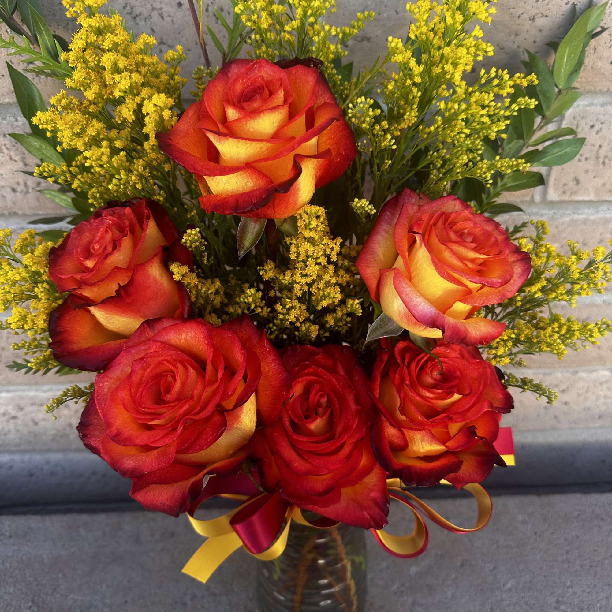 Bouquet of red and yellow roses in a glass vase