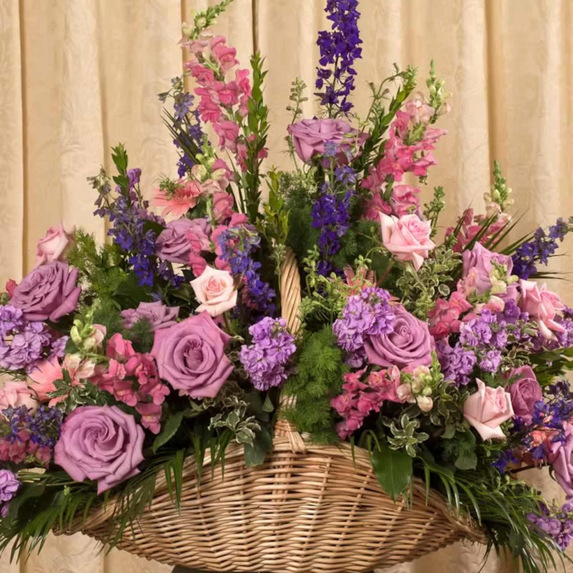 Large basket arrangement of purple and pink flowers